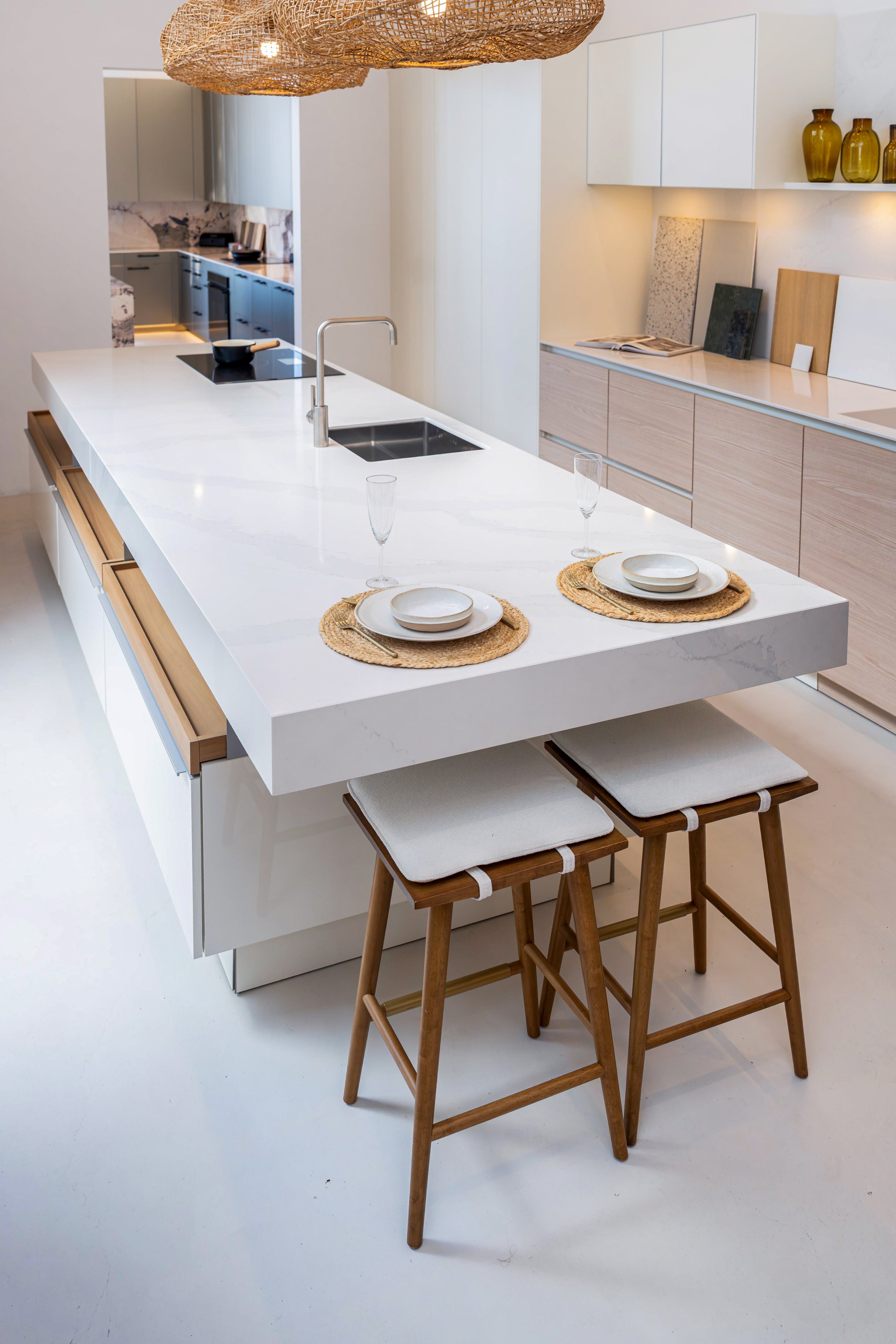 Modern German engineered handleless kitchen island showing ultra reflective polished white lacquer finish