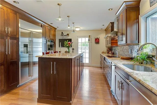 Kraftmaid Transitional Dark Wooden Kitchen with Marble Countertops and GE Monogram Appliances