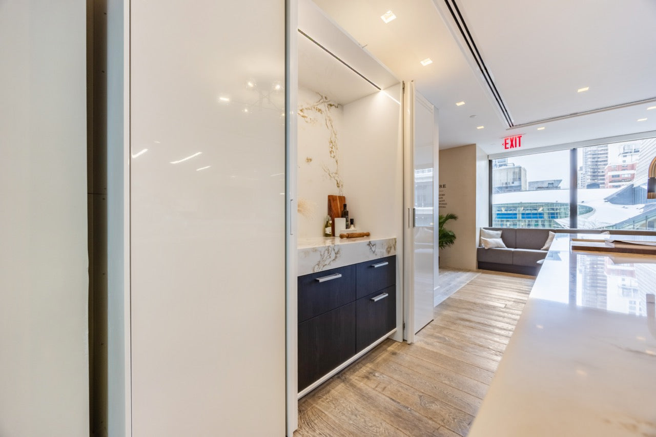 SieMatic Modern Rose Gold Handleless Island with Lotus White Hideaway Pantry with Pocket Doors
