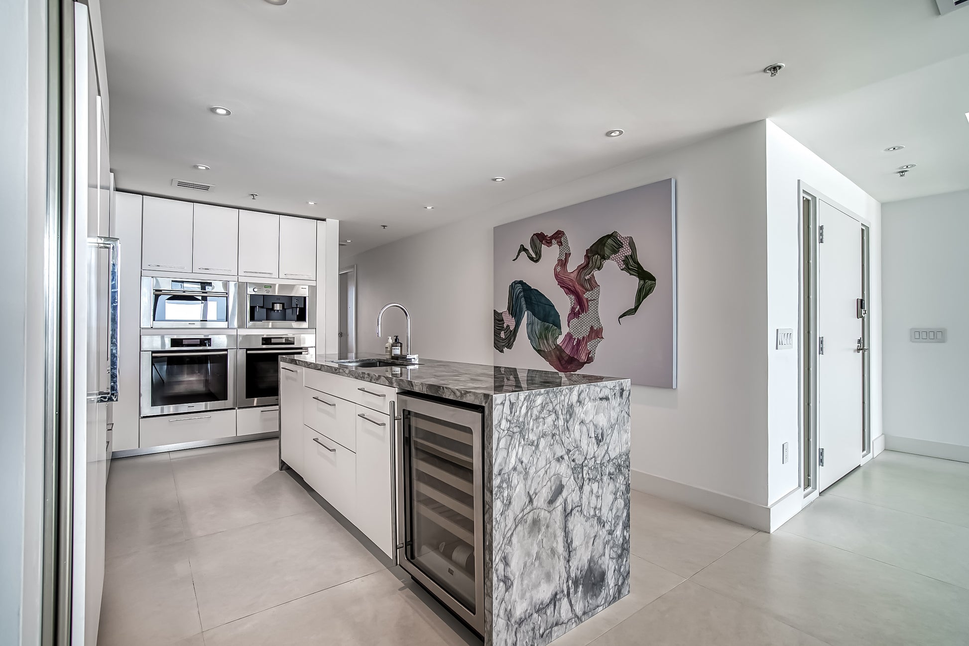 Poggenpohl White Modern Kitchen with Waterfall Island, Marble Countertops and Miele Appliances