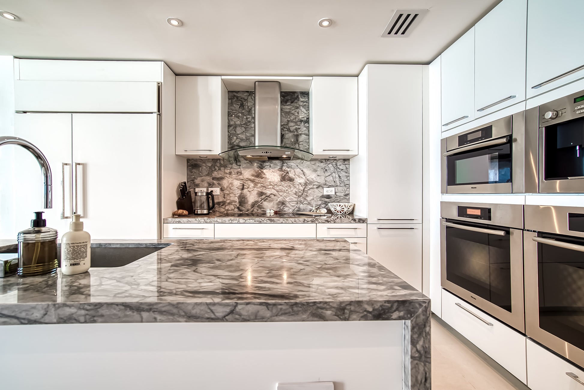 Poggenpohl White Modern Kitchen with Waterfall Island, Marble Countertops and Miele Appliances