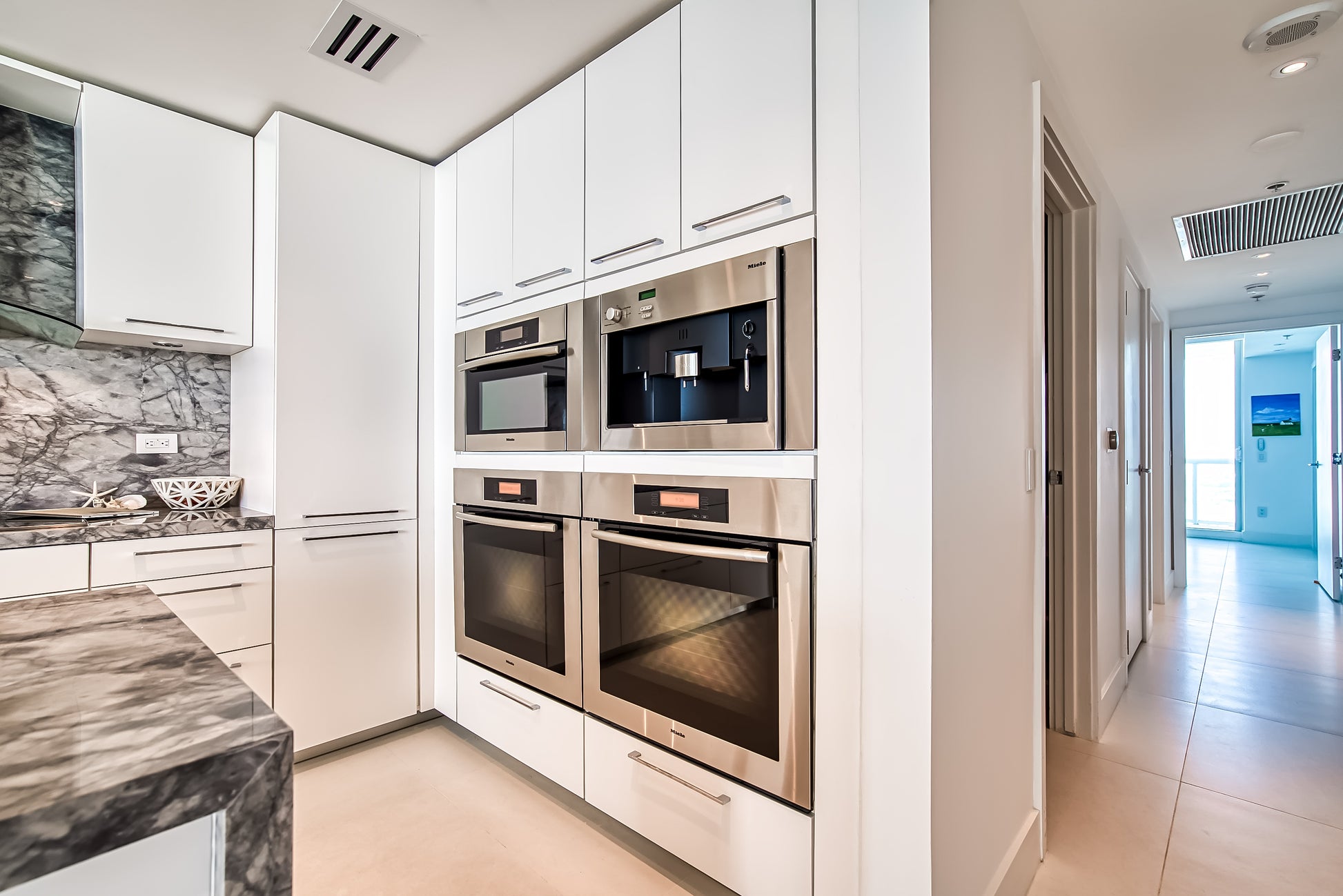 Poggenpohl White Modern Kitchen with Waterfall Island, Marble Countertops and Miele Appliances