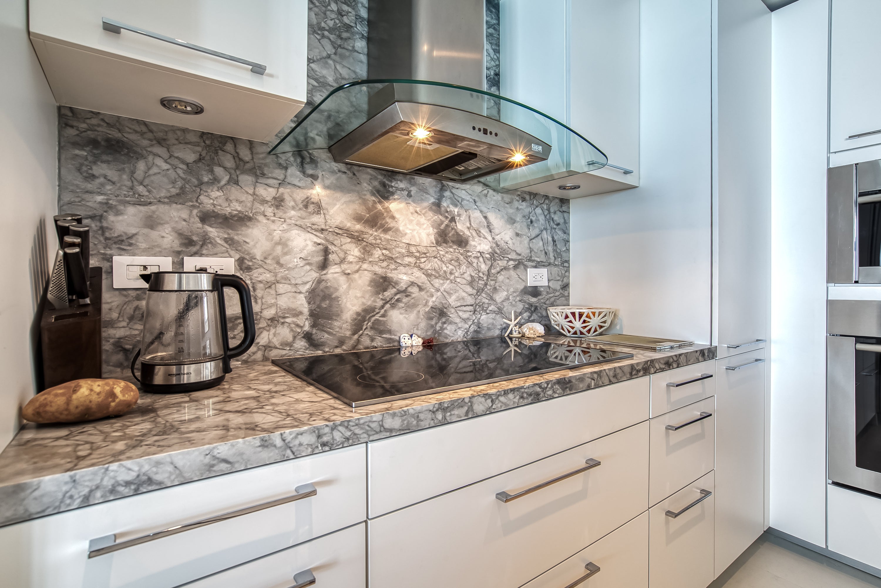 Poggenpohl White Modern Kitchen with Waterfall Island, Marble Countertops and Miele Appliances