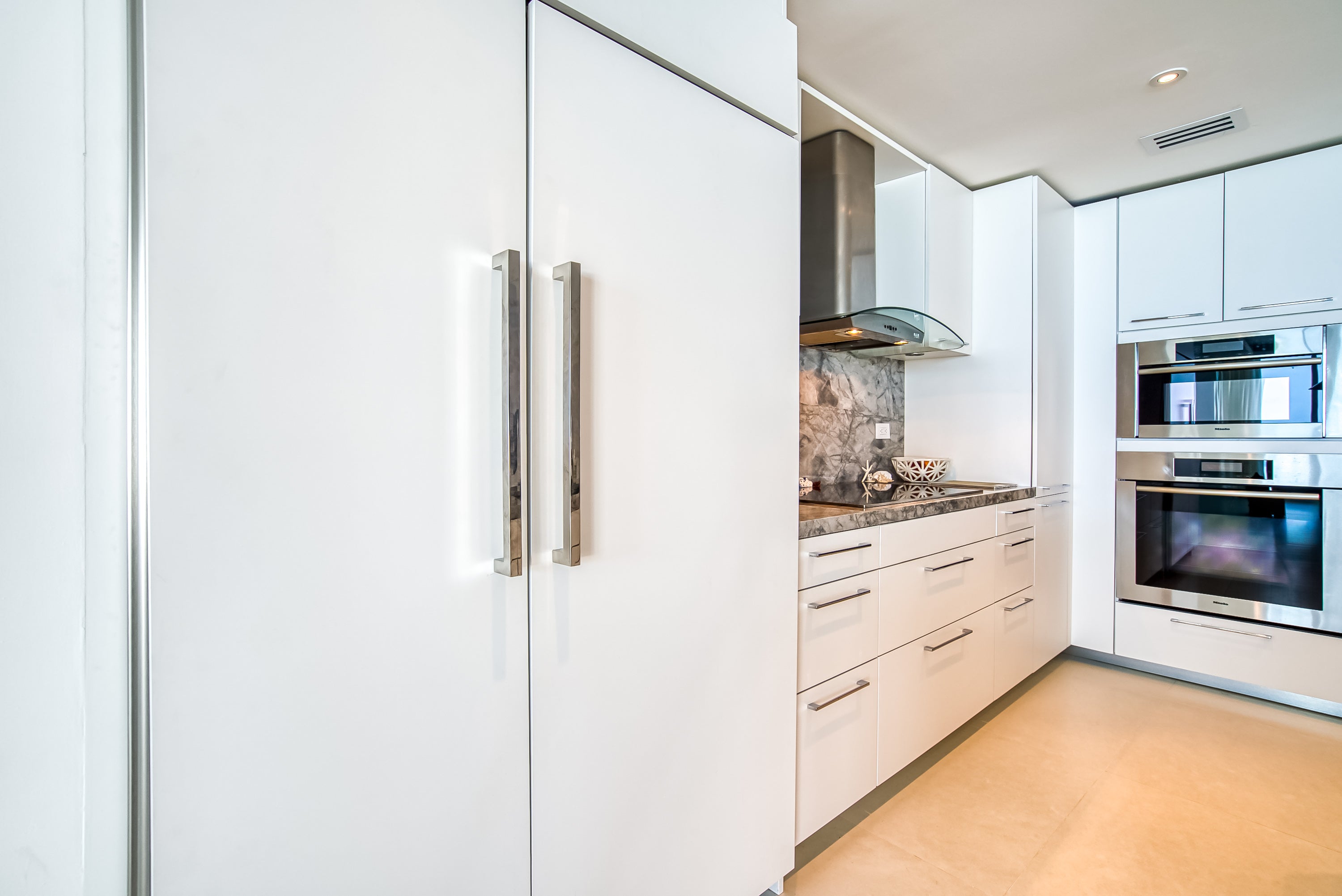 Poggenpohl White Modern Kitchen with Waterfall Island, Marble Countertops and Miele Appliances