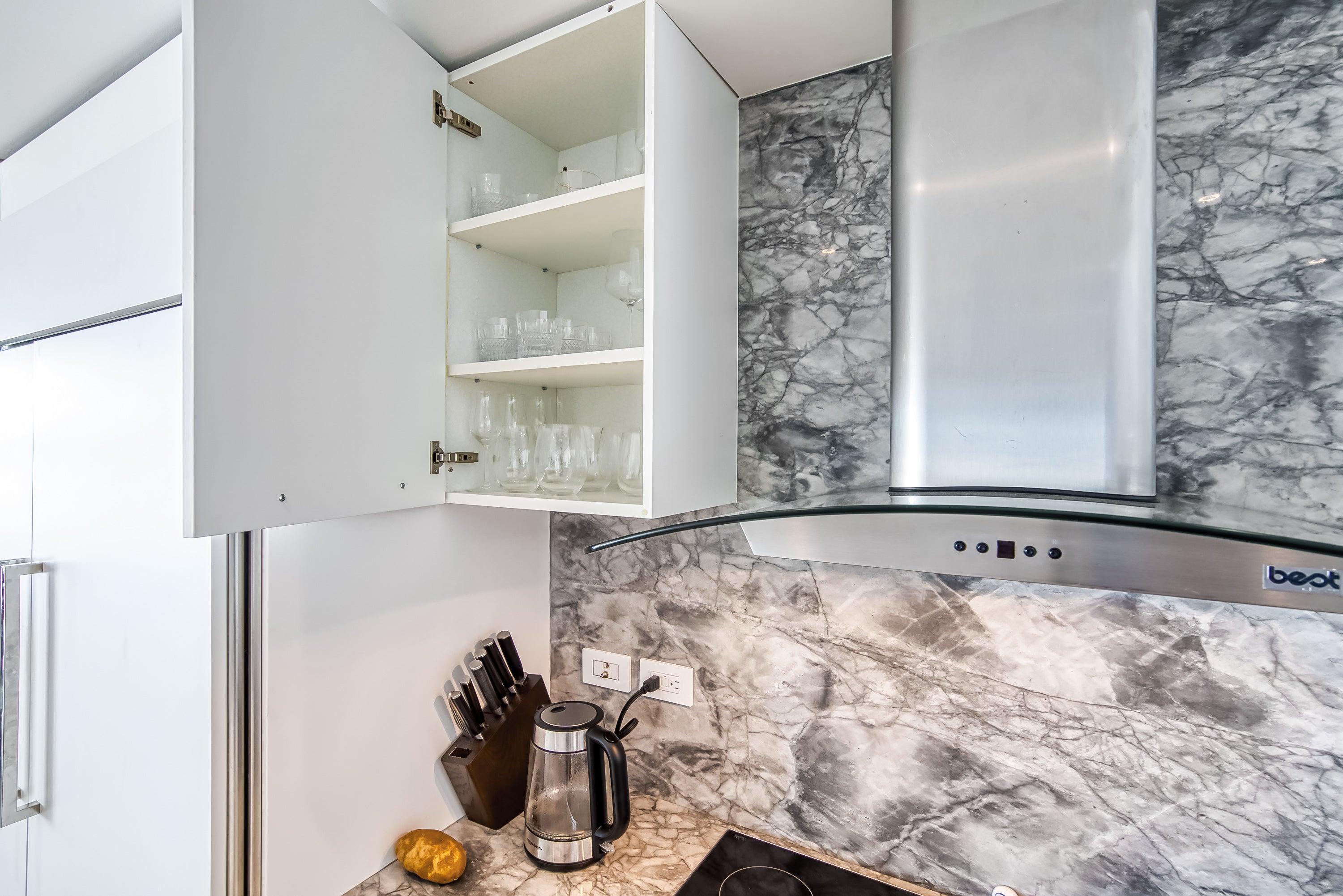 Poggenpohl White Modern Kitchen with Waterfall Island, Marble Countertops and Miele Appliances