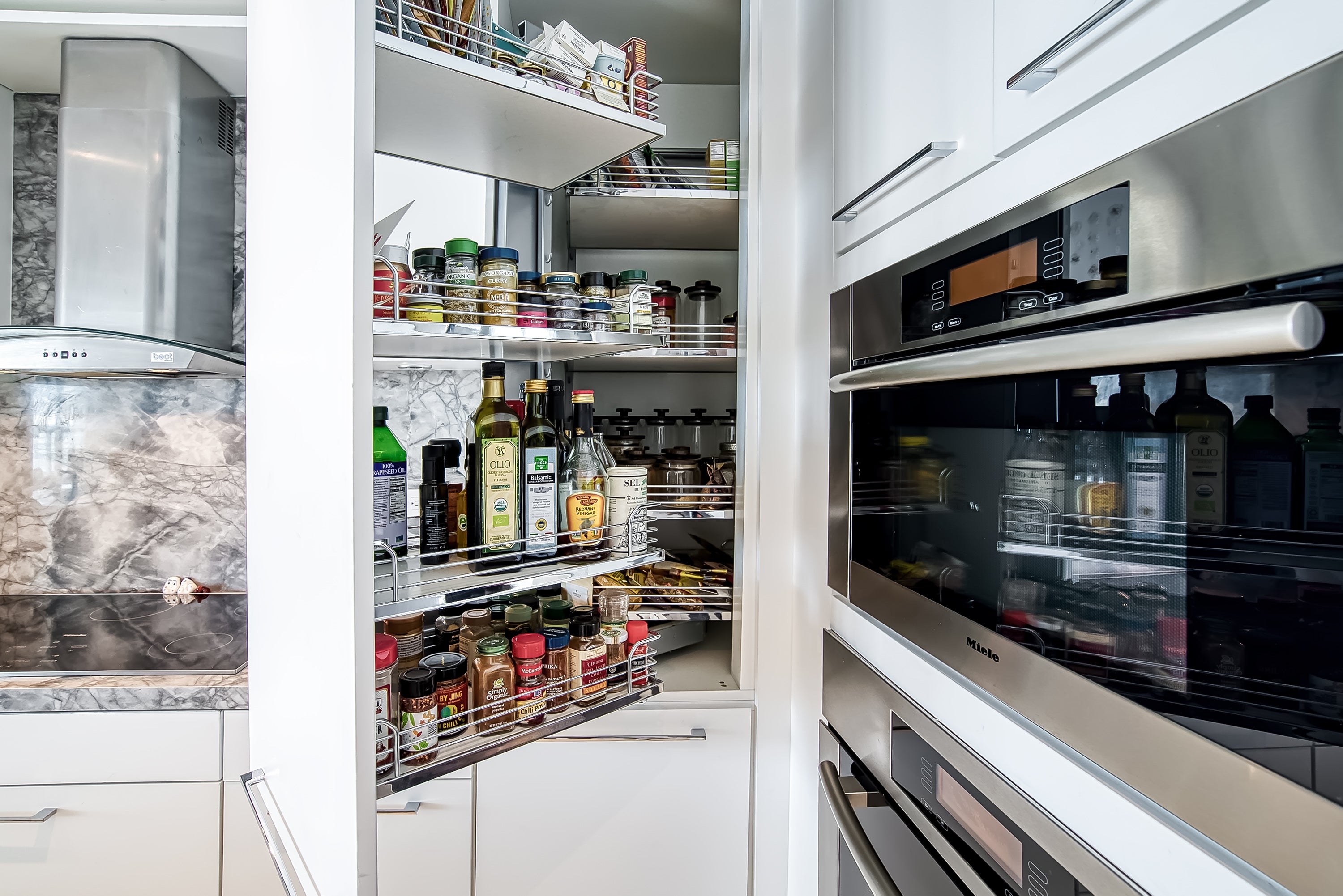 Poggenpohl White Modern Kitchen with Waterfall Island, Marble Countertops and Miele Appliances