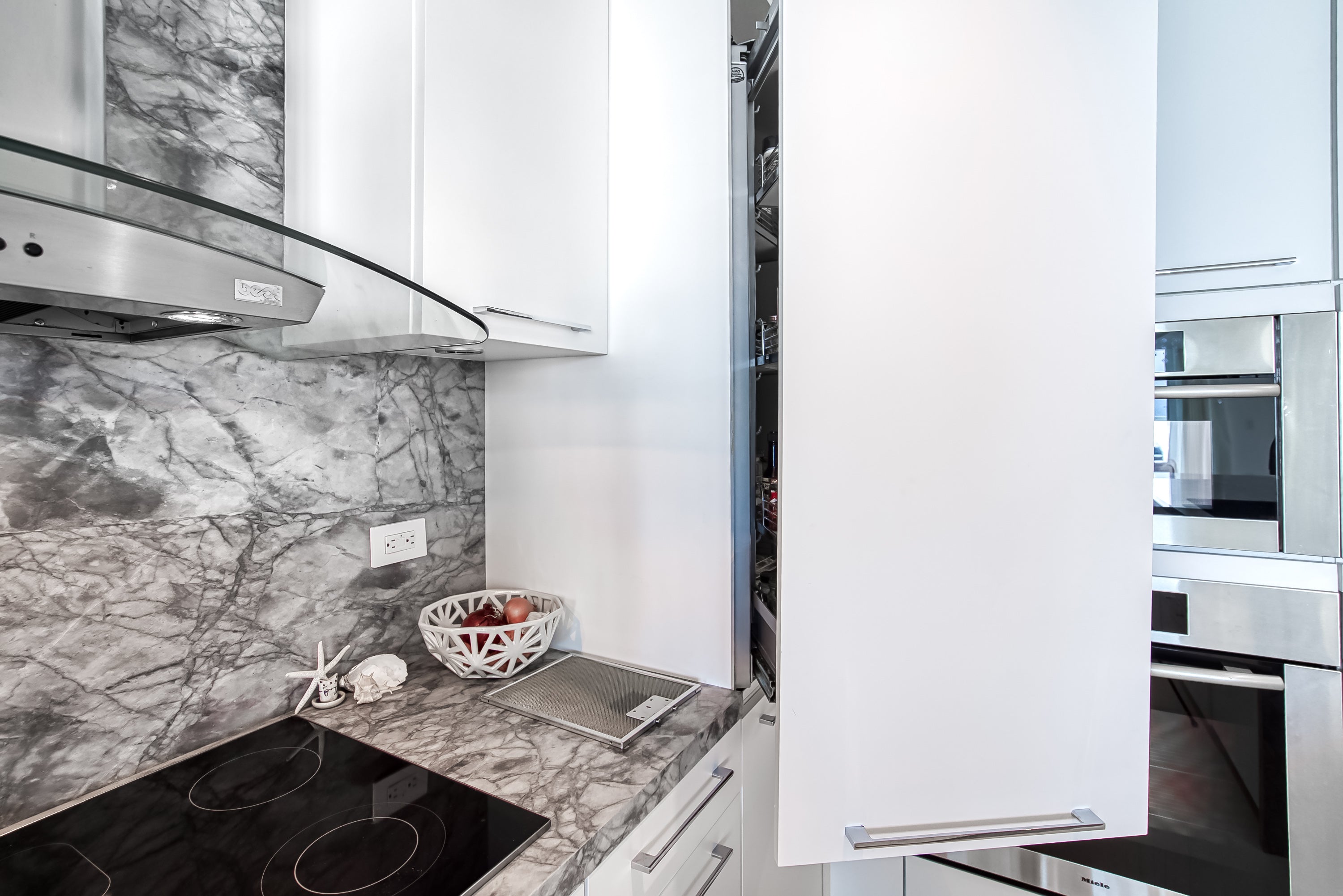Poggenpohl White Modern Kitchen with Waterfall Island, Marble Countertops and Miele Appliances