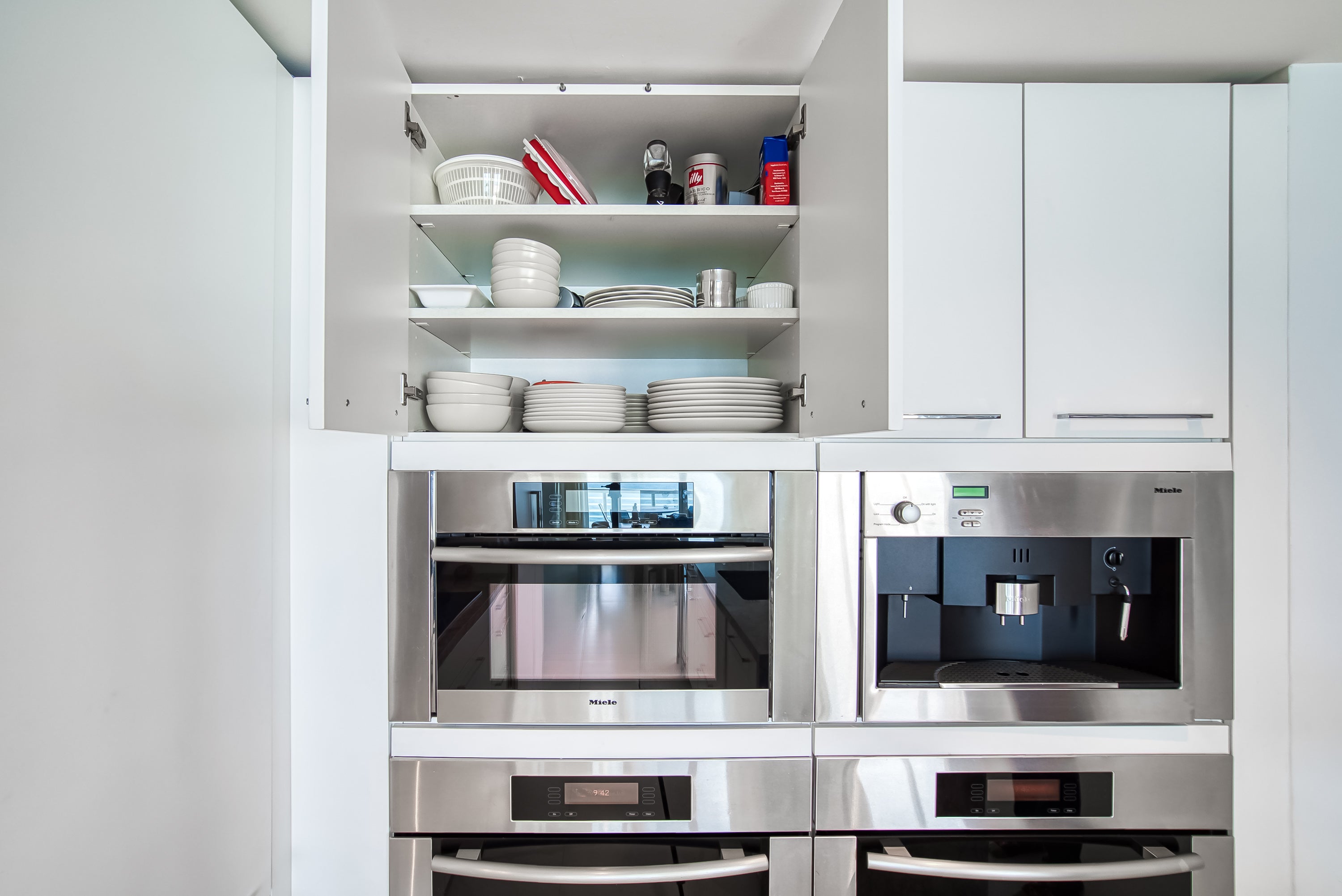 Poggenpohl White Modern Kitchen with Waterfall Island, Marble Countertops and Miele Appliances