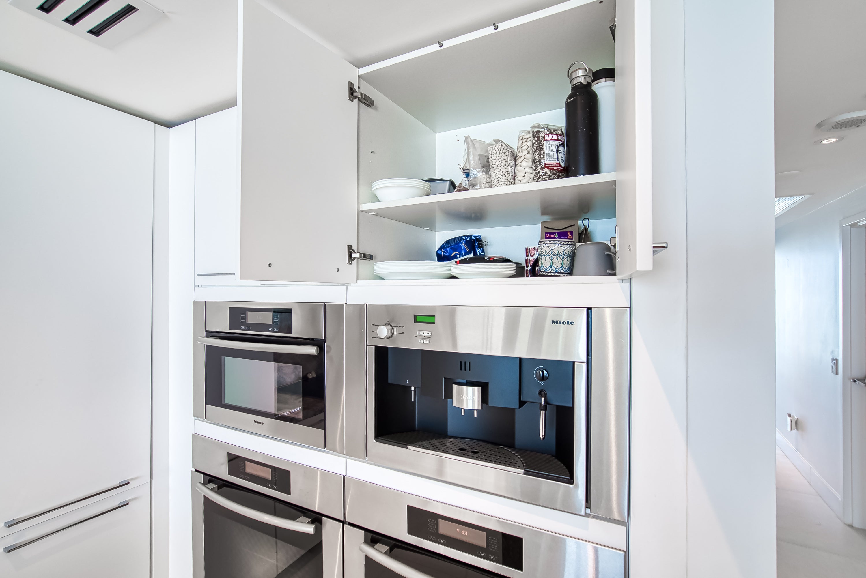 Poggenpohl White Modern Kitchen with Waterfall Island, Marble Countertops and Miele Appliances