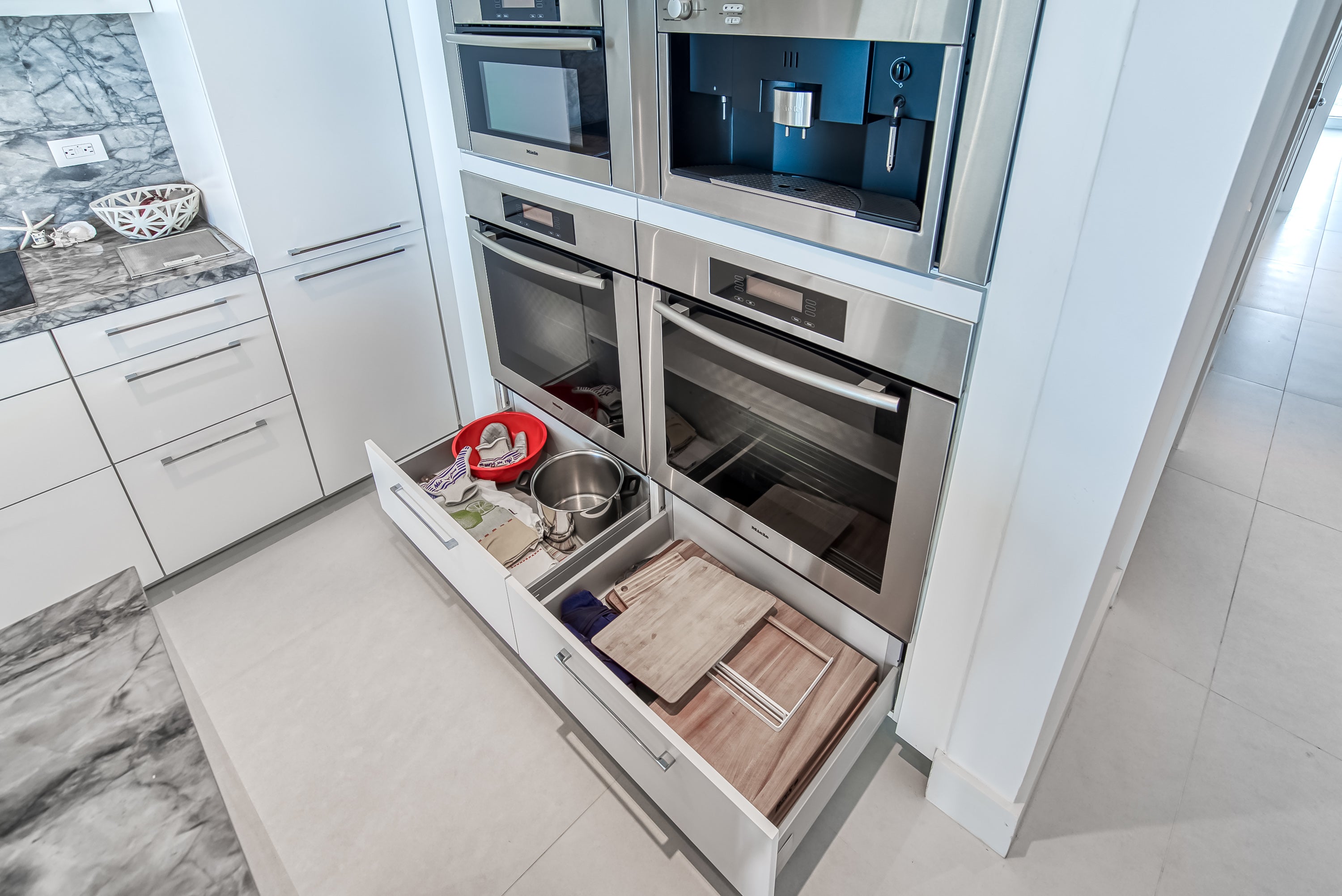 Poggenpohl White Modern Kitchen with Waterfall Island, Marble Countertops and Miele Appliances