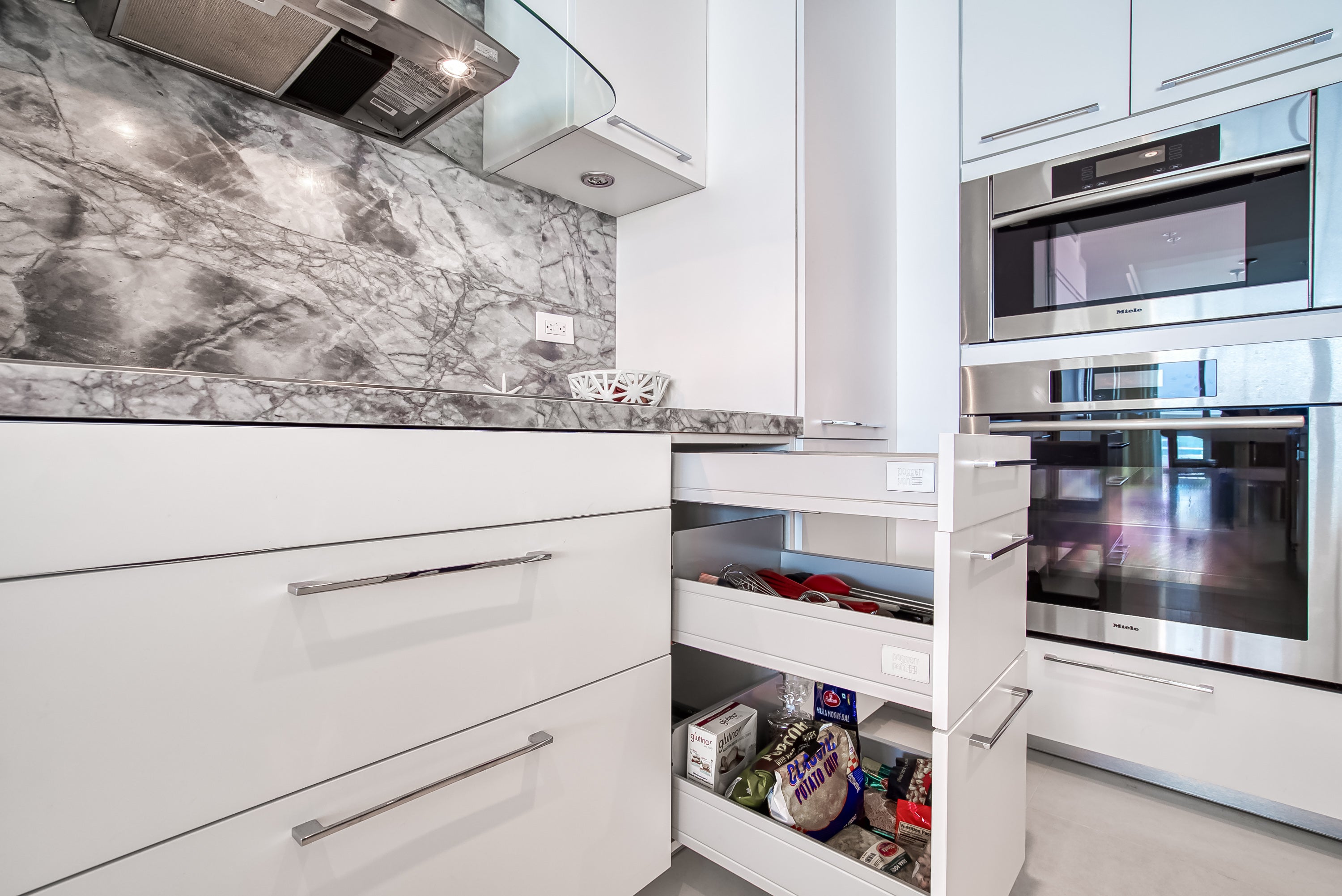 Poggenpohl White Modern Kitchen with Waterfall Island, Marble Countertops and Miele Appliances