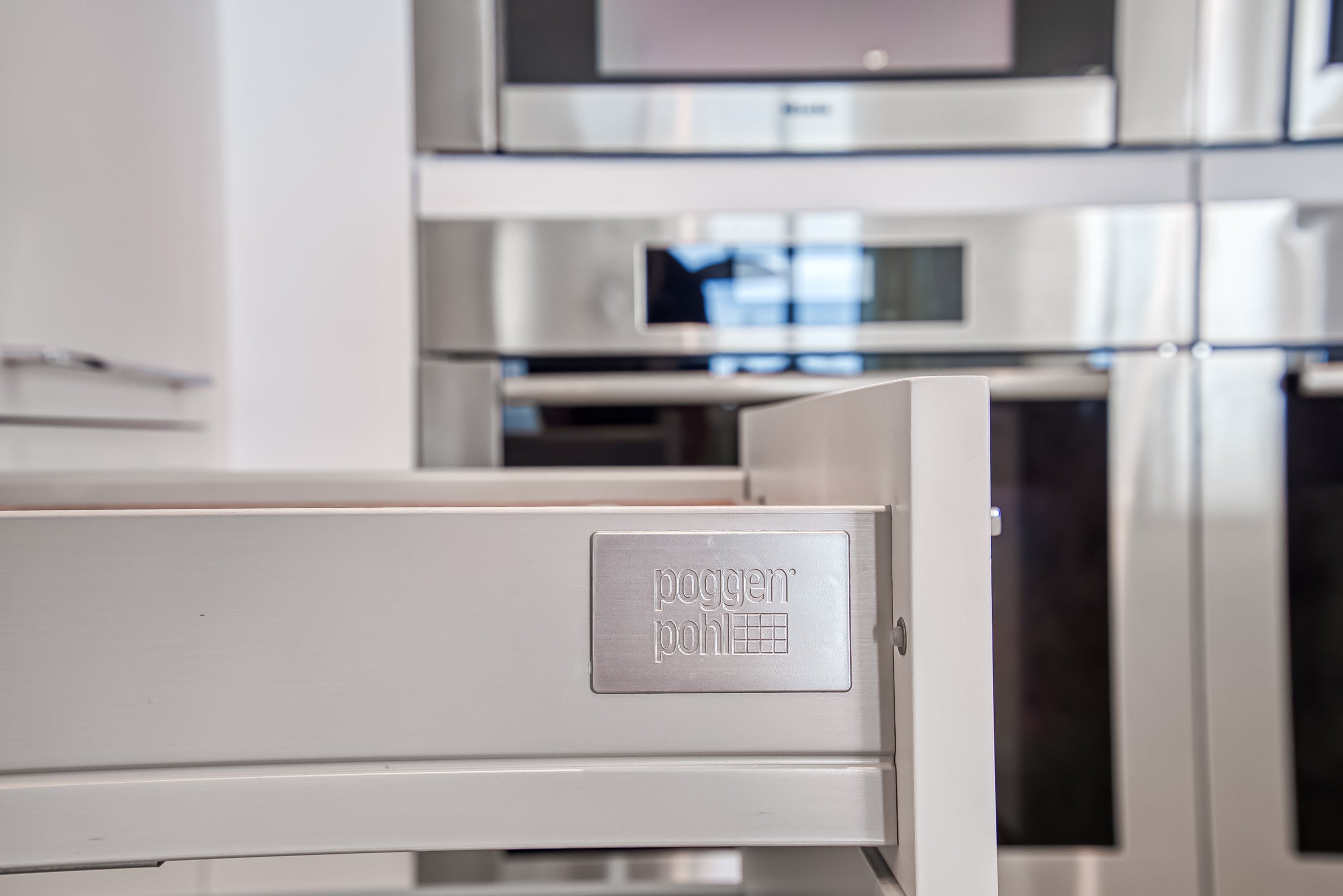 Poggenpohl White Modern Kitchen with Waterfall Island, Marble Countertops and Miele Appliances