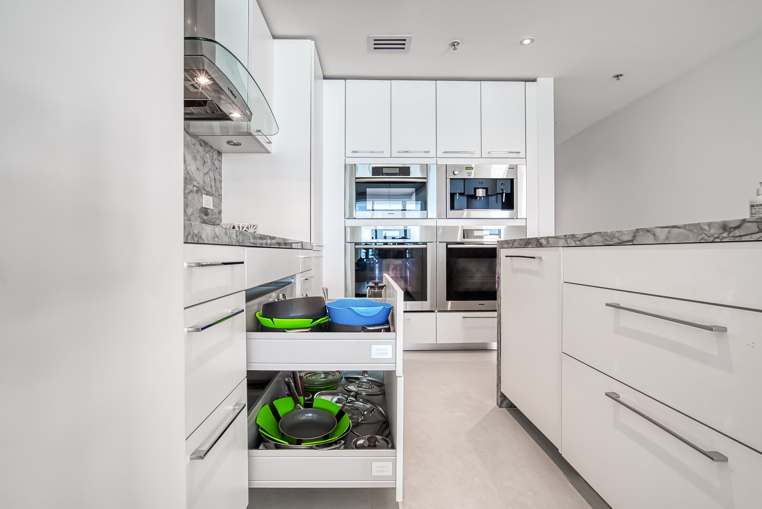 Poggenpohl White Modern Kitchen with Waterfall Island, Marble Countertops and Miele Appliances