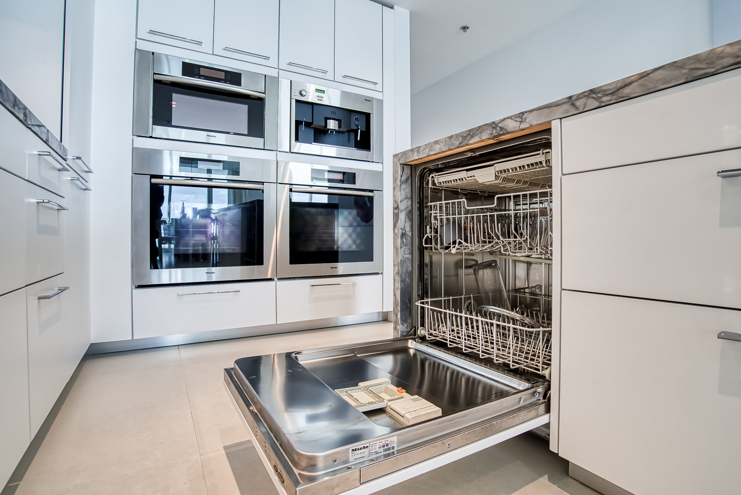 Poggenpohl White Modern Kitchen with Waterfall Island, Marble Countertops and Miele Appliances
