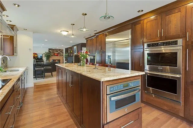 Kraftmaid Transitional Dark Wooden Kitchen with Marble Countertops and GE Monogram Appliances