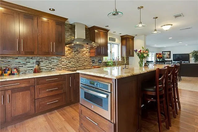 Kraftmaid Transitional Dark Wooden Kitchen with Marble Countertops and GE Monogram Appliances