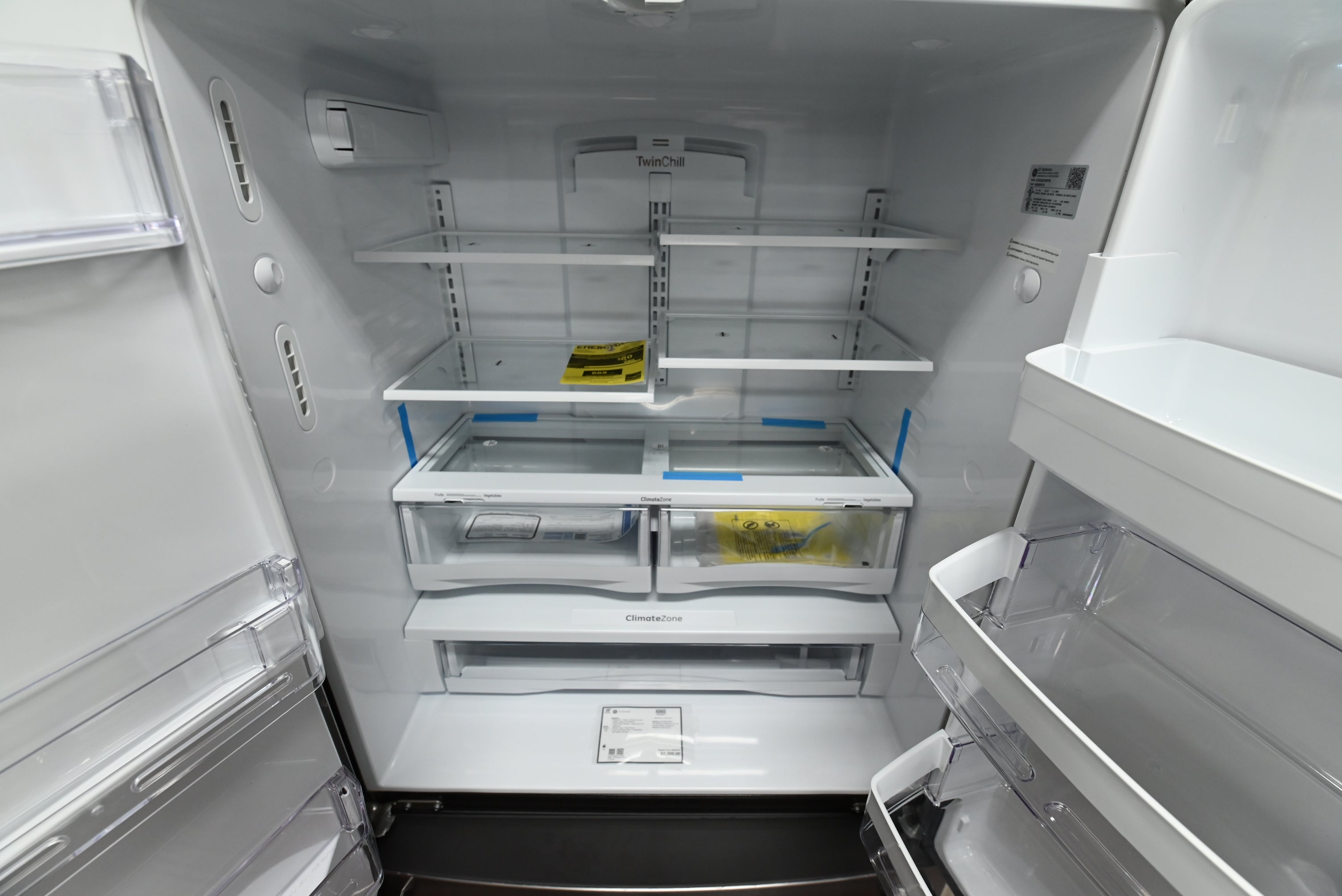 Interior view of the open fresh food shelves and LED lighting inside the GE GYE22GYNFS counter-depth refrigerator