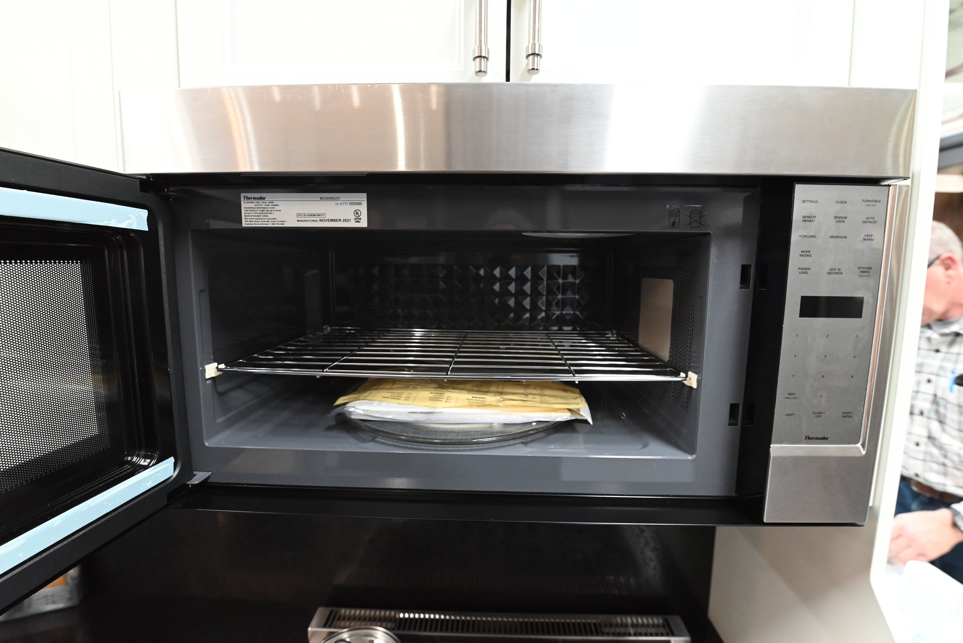 Luxury 30 inch integrated microwave oven open showing 2.1 cubic feet cavity and internal wire rack