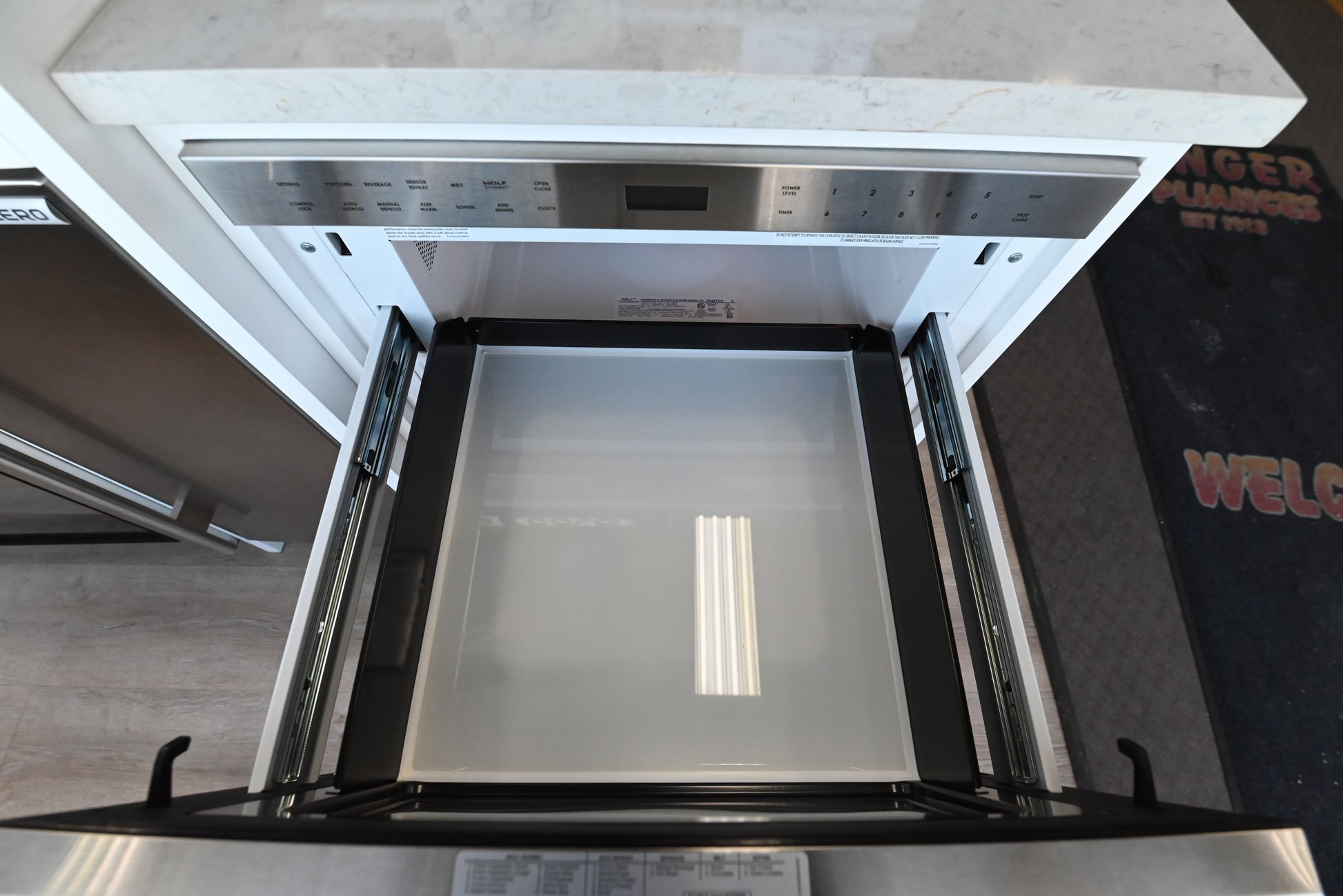 Luxury under counter 24 inch microwave drawer by Wolf showing open cavity holding large pan