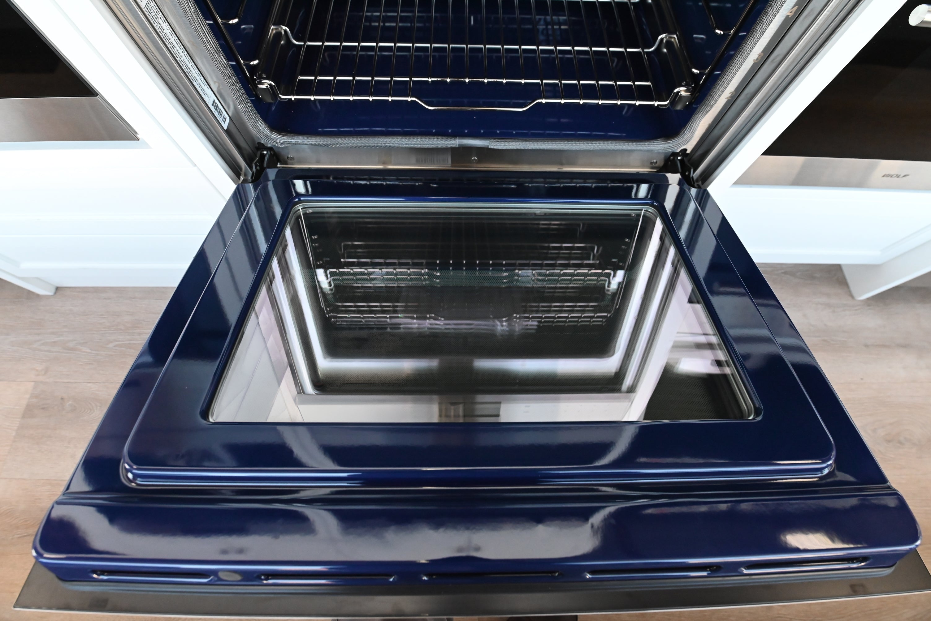 Wolf 30 M series oven open showing full extension glide racks and blue porcelain cavity