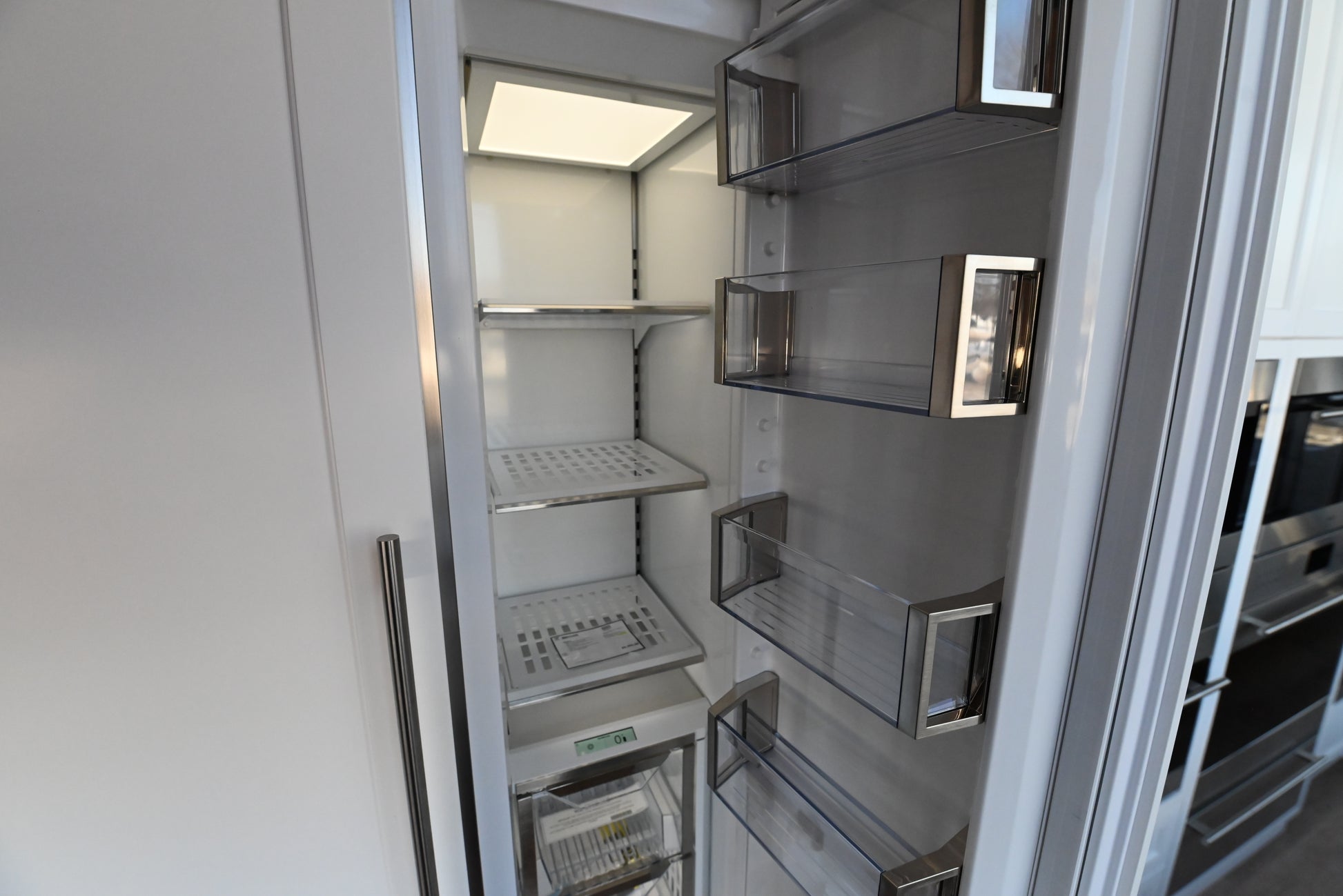Sub Zero 18 inch freezer column showing open door wire shelving drawers and LED lights