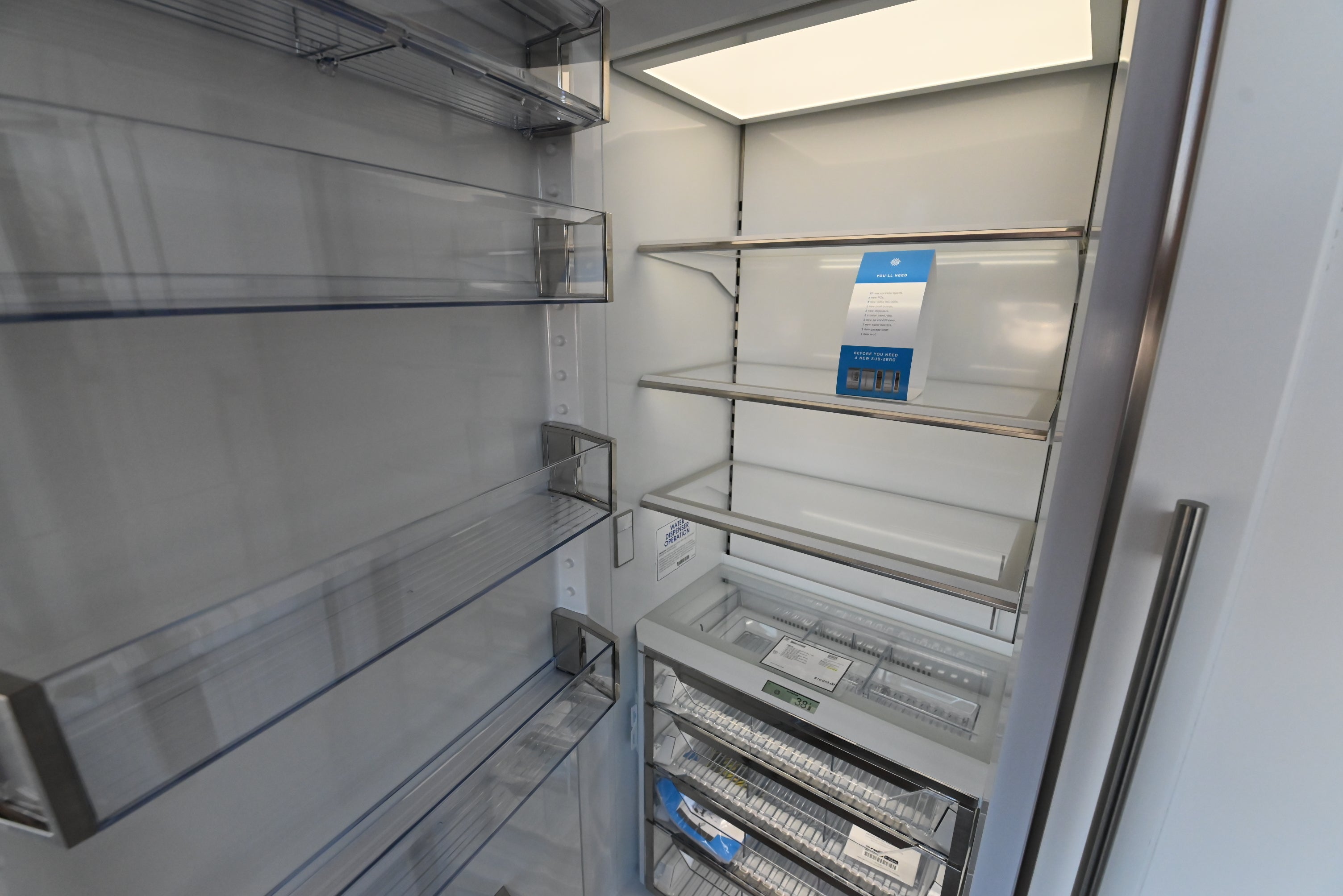 Sub Zero 30 inch refrigerator column showing open door glass shelving crisper drawers and LED lights