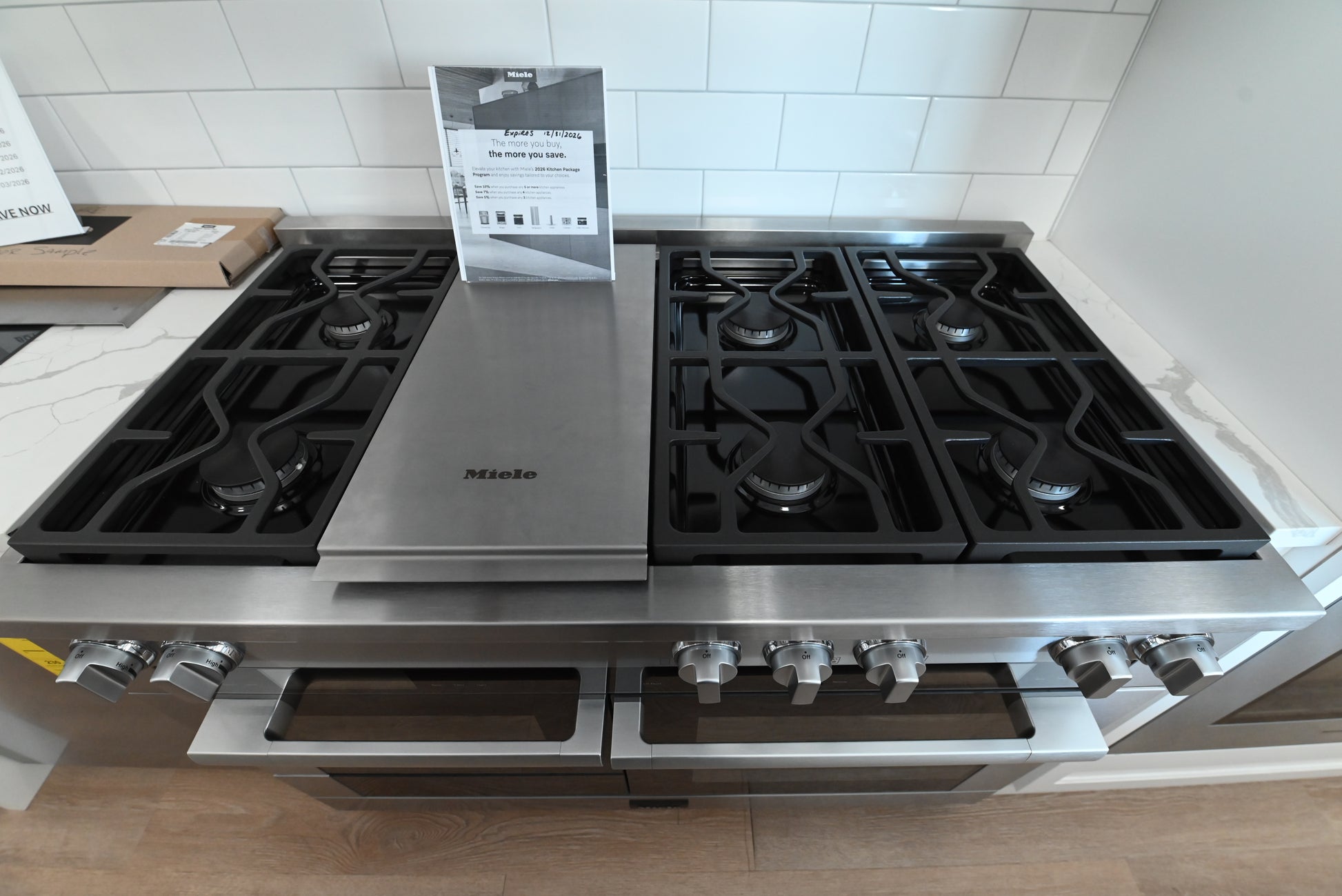 Miele professional 48 inch range showing open convection oven doors and motorized control panel