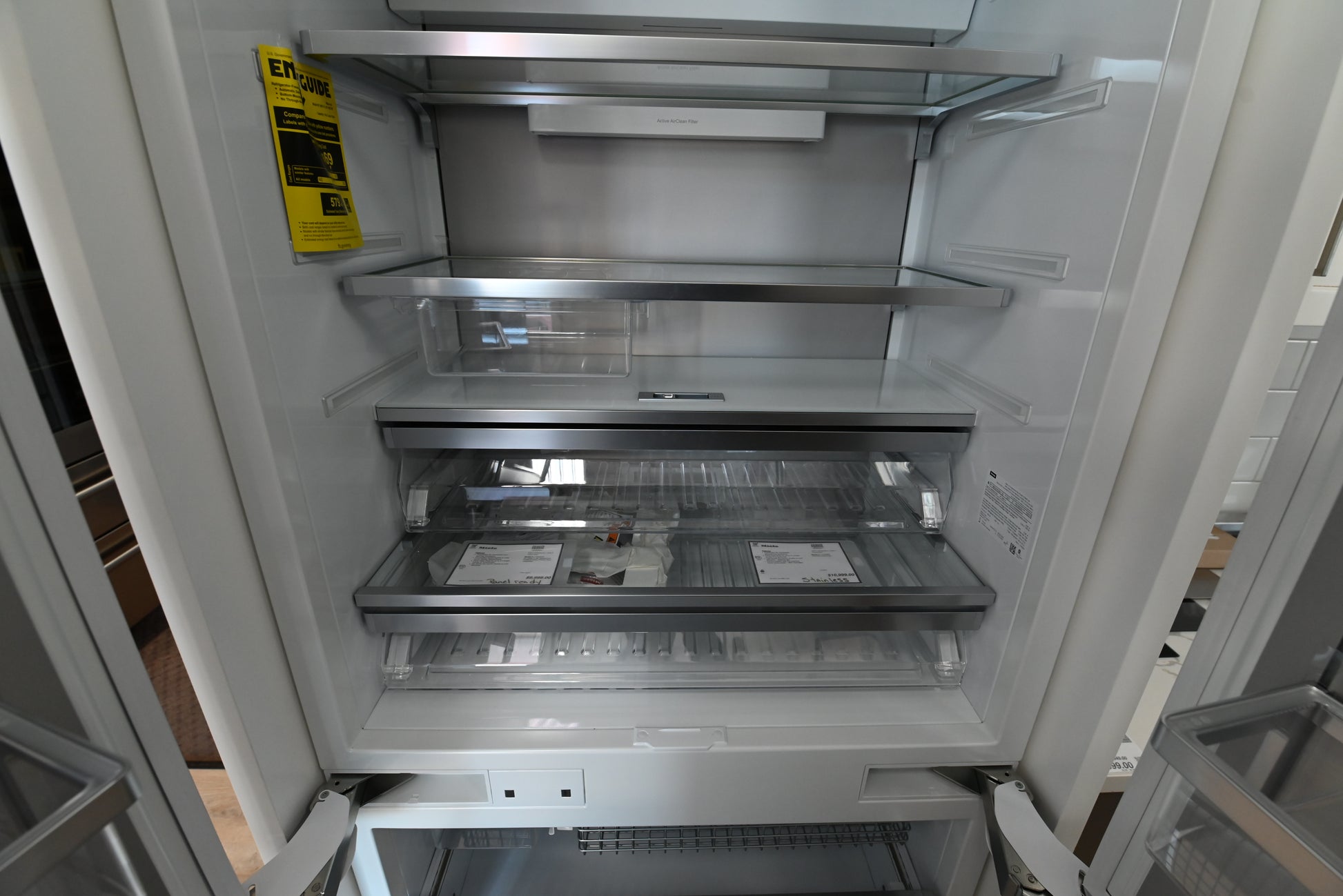 Miele MasterCool French Door fridge showing open interior glass shelves and double freezer drawers