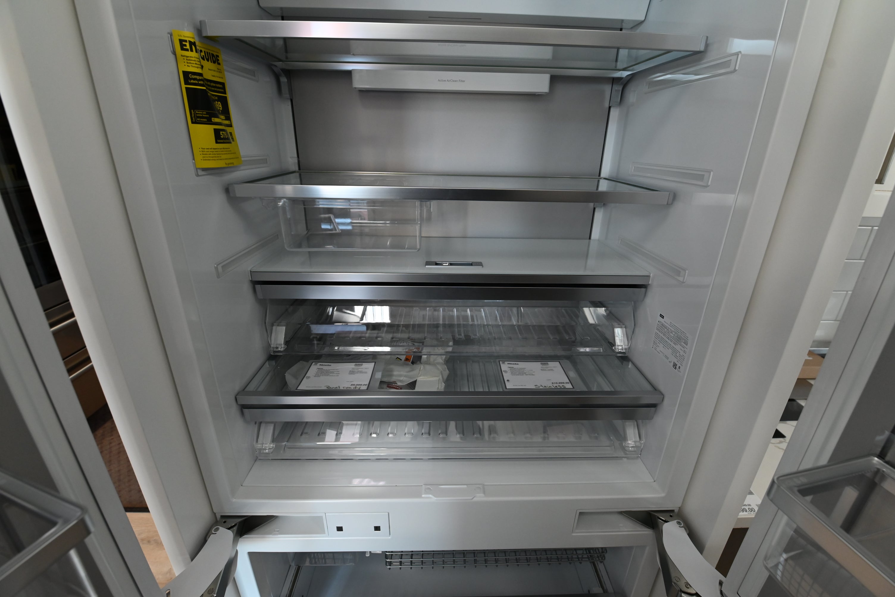 Miele MasterCool French Door fridge showing open interior glass shelves and double freezer drawers