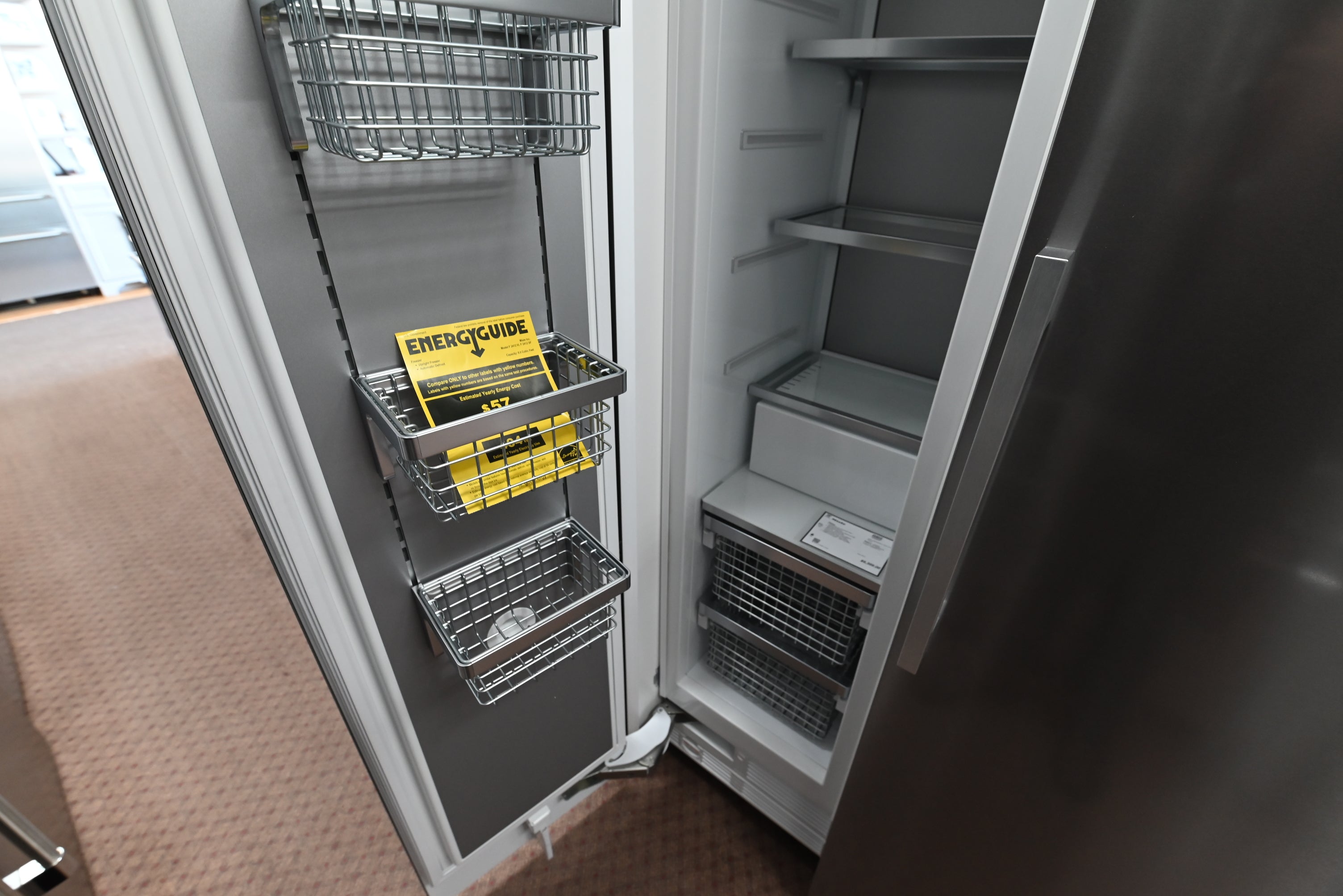 Miele MasterCool 18 inch column freezer showing open door ice maker and bright LED lights