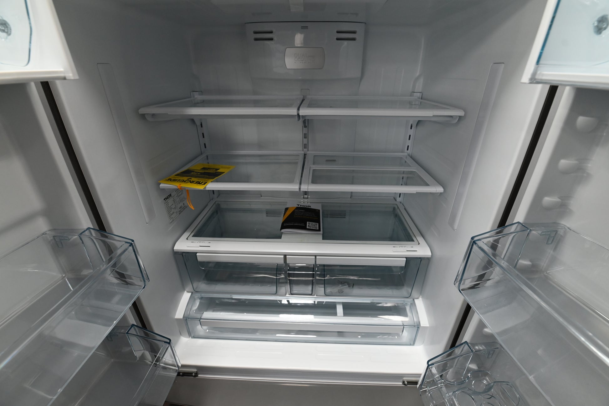 Luxury 36 inch 4 door pro refrigerator open showing glass shelves and full width chiller drawer