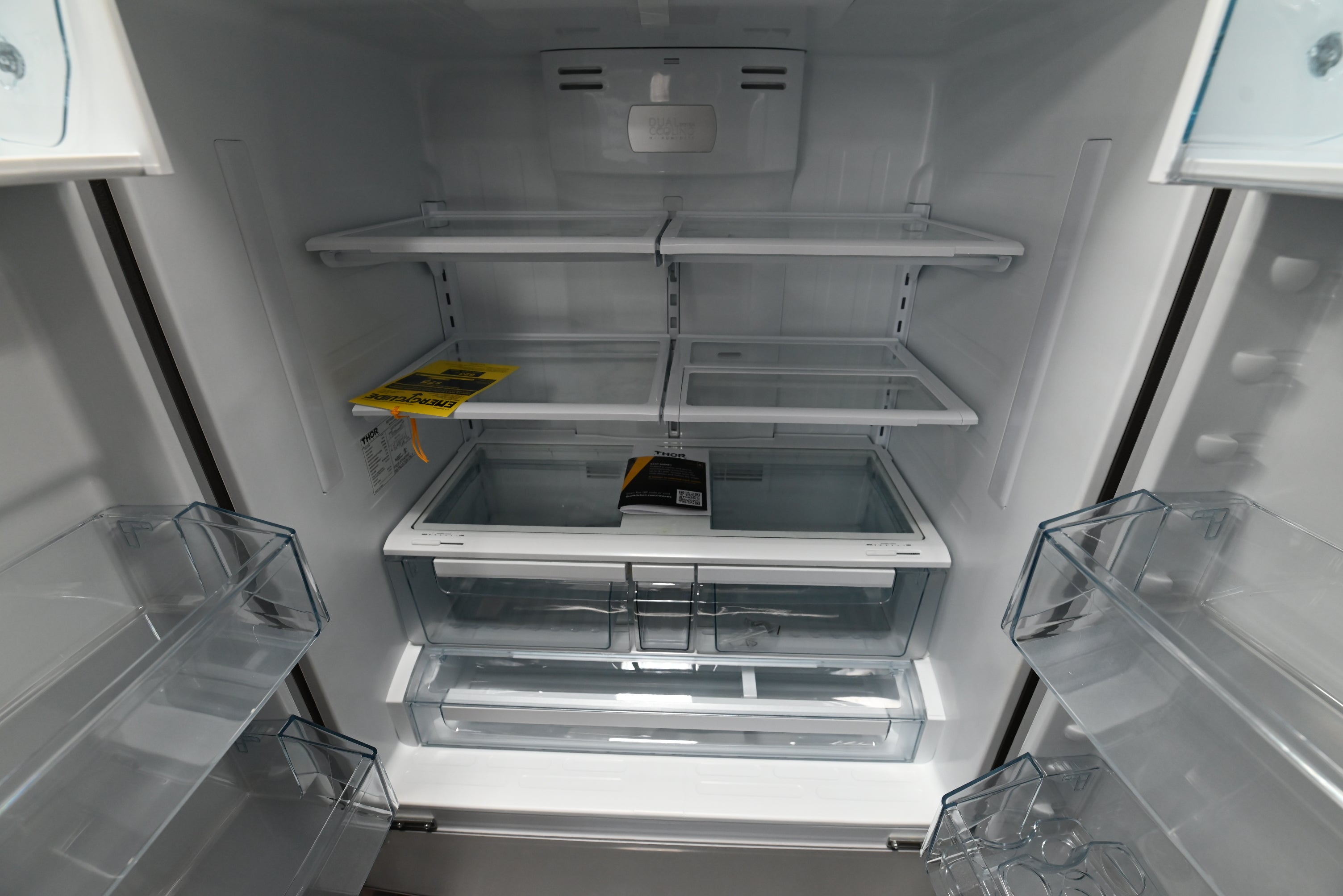 Luxury 36 inch 4 door pro refrigerator open showing glass shelves and full width chiller drawer