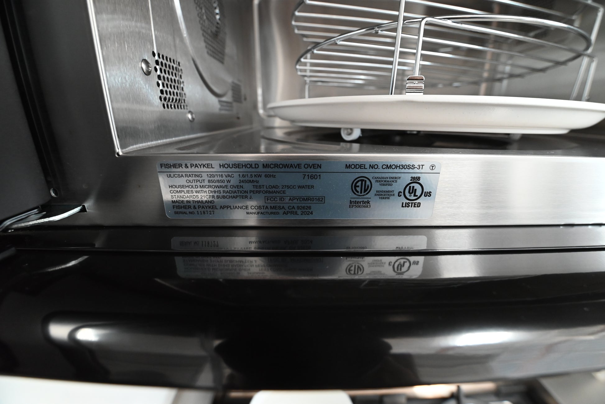 Underside view of the Fisher Paykel over the range microwave showing integrated cooktop lights and vent filters
