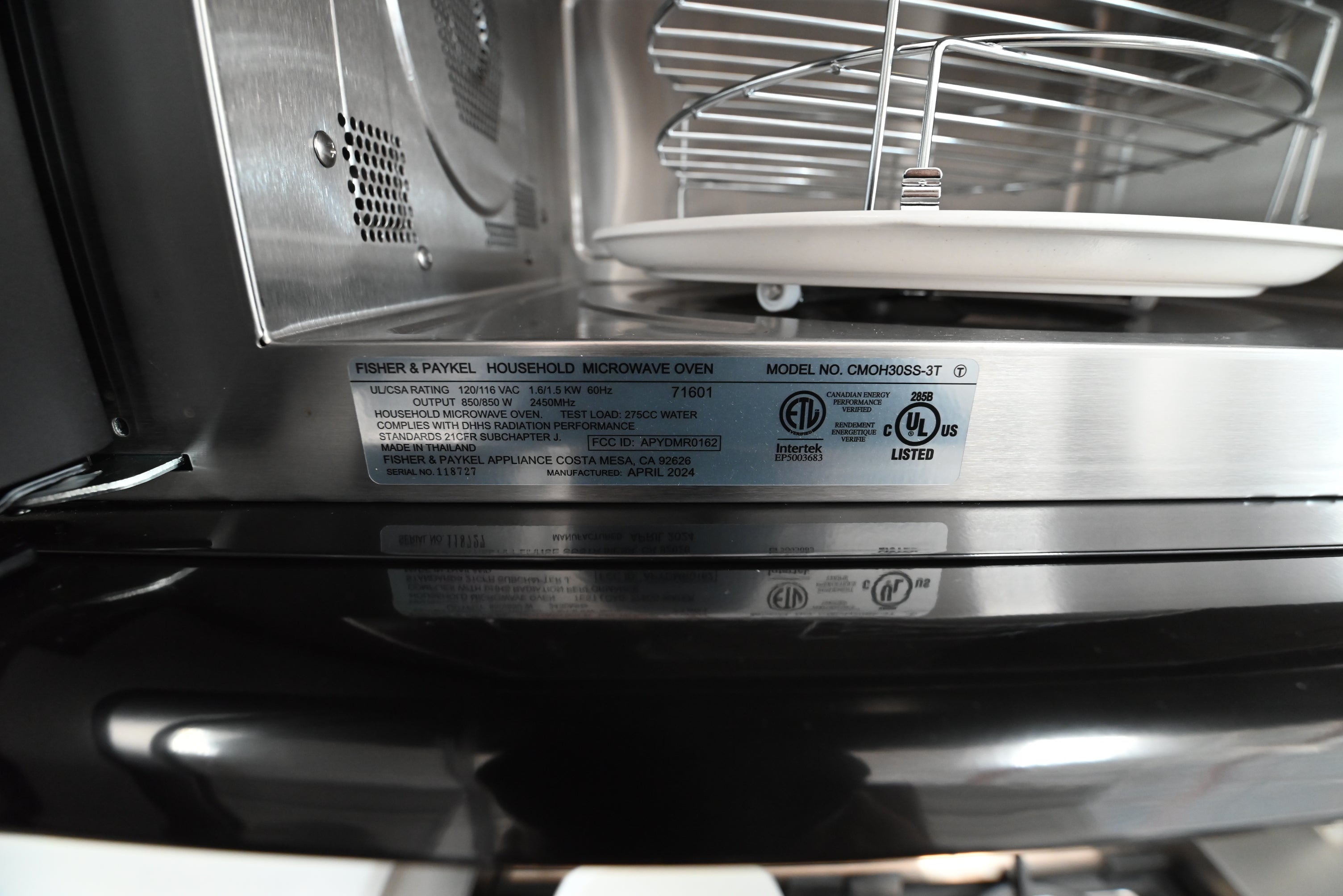 Underside view of the Fisher Paykel over the range microwave showing integrated cooktop lights and vent filters