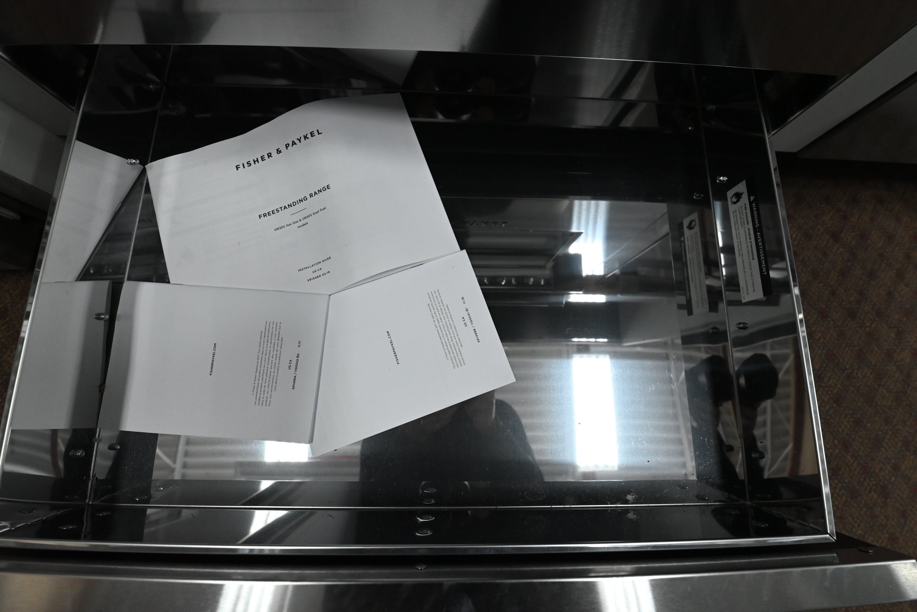 Three white printed documents or booklets labeled 'PISNER & PATERNL' and 'PENSILVANIA EXPRESS' resting inside a reflective black glass drawer or cabinet.