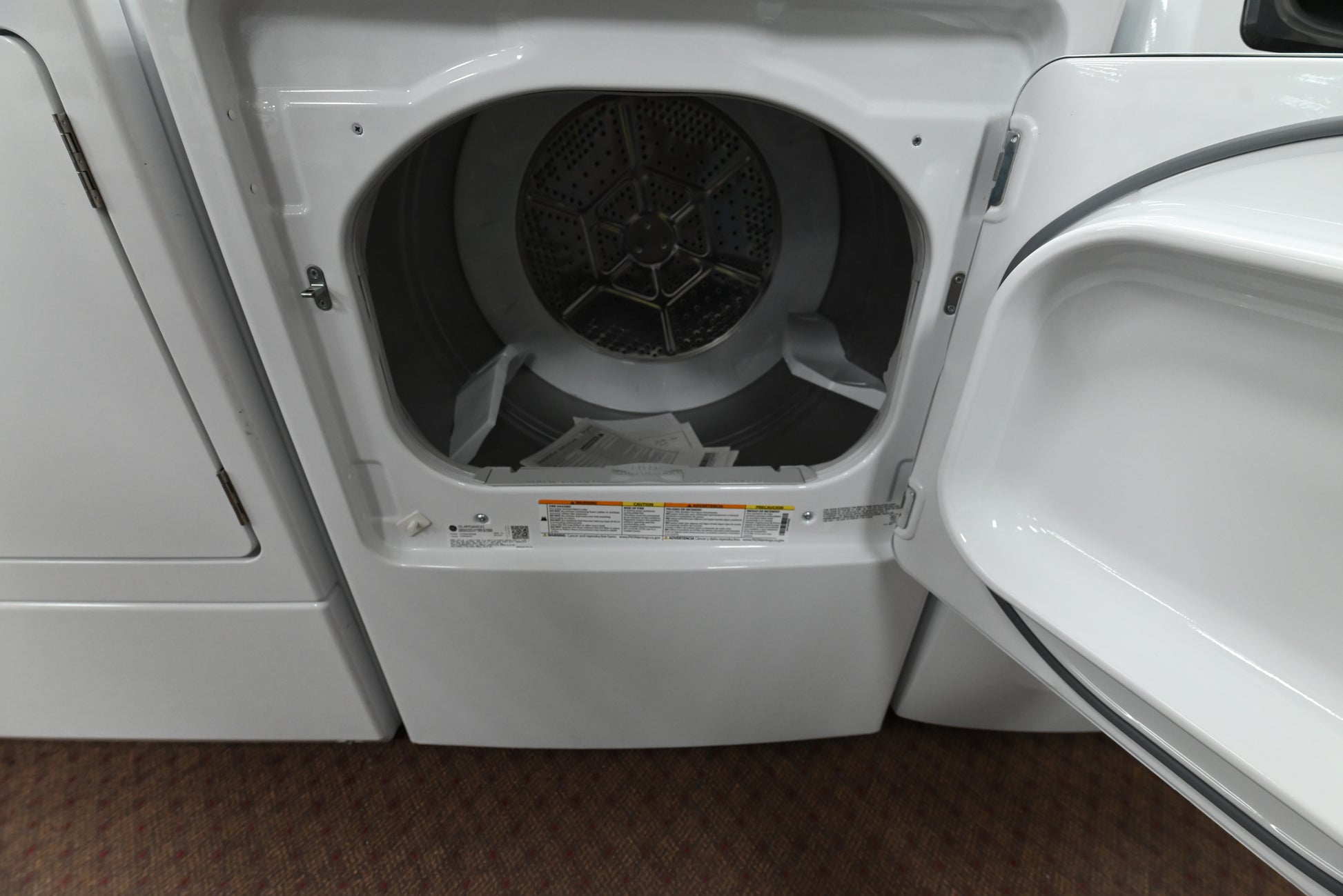 Close up view of the electromechanical control knobs and 5 year warranty label on the GE GTX52GASPWB dryer