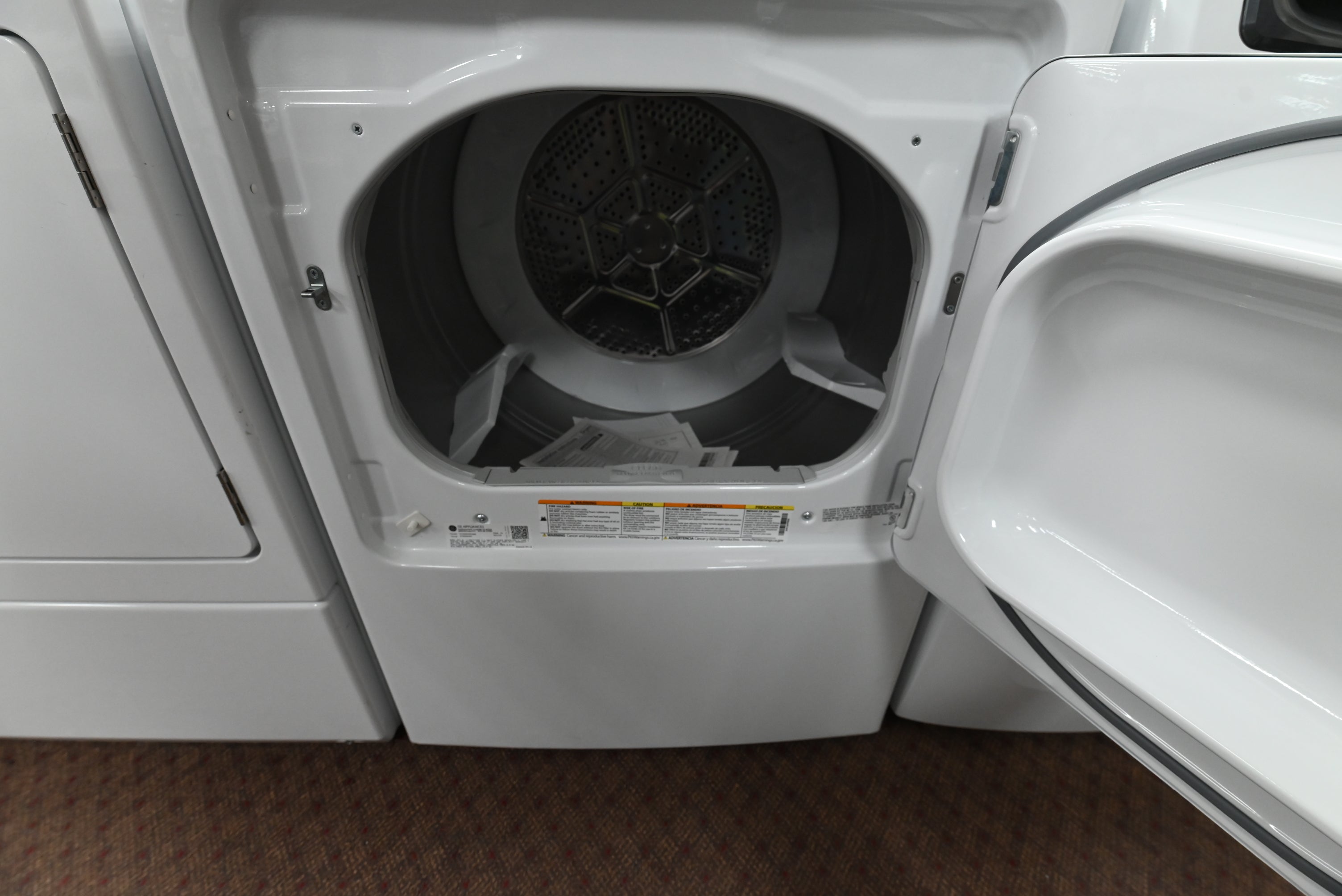 Close up view of the electromechanical control knobs and 5 year warranty label on the GE GTX52GASPWB dryer
