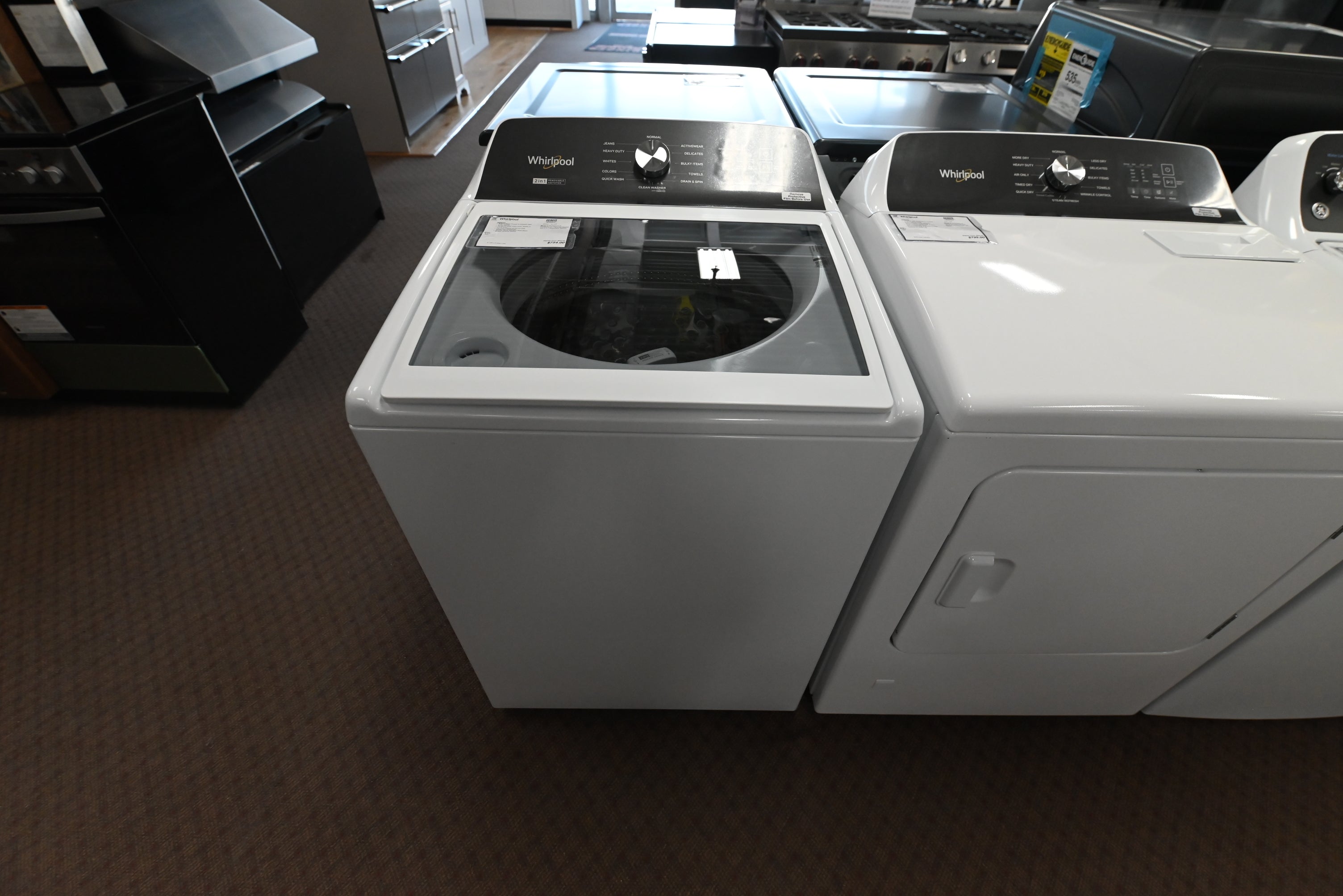 Whirlpool top load washer WTW5057LW in white with transparent glass lid open