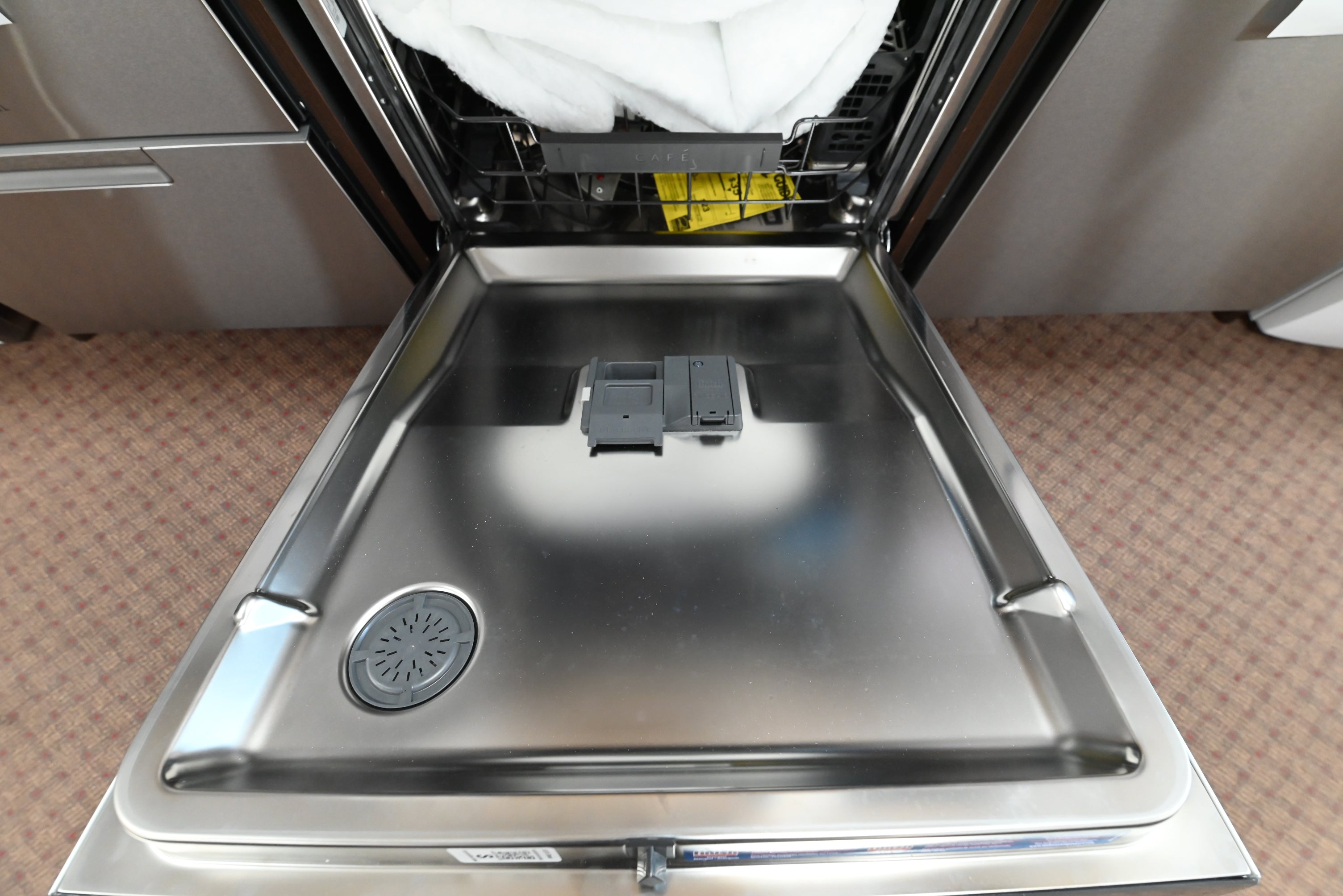 Cafe smart white dishwasher showing open door and premium adjustable upper nylon racks
