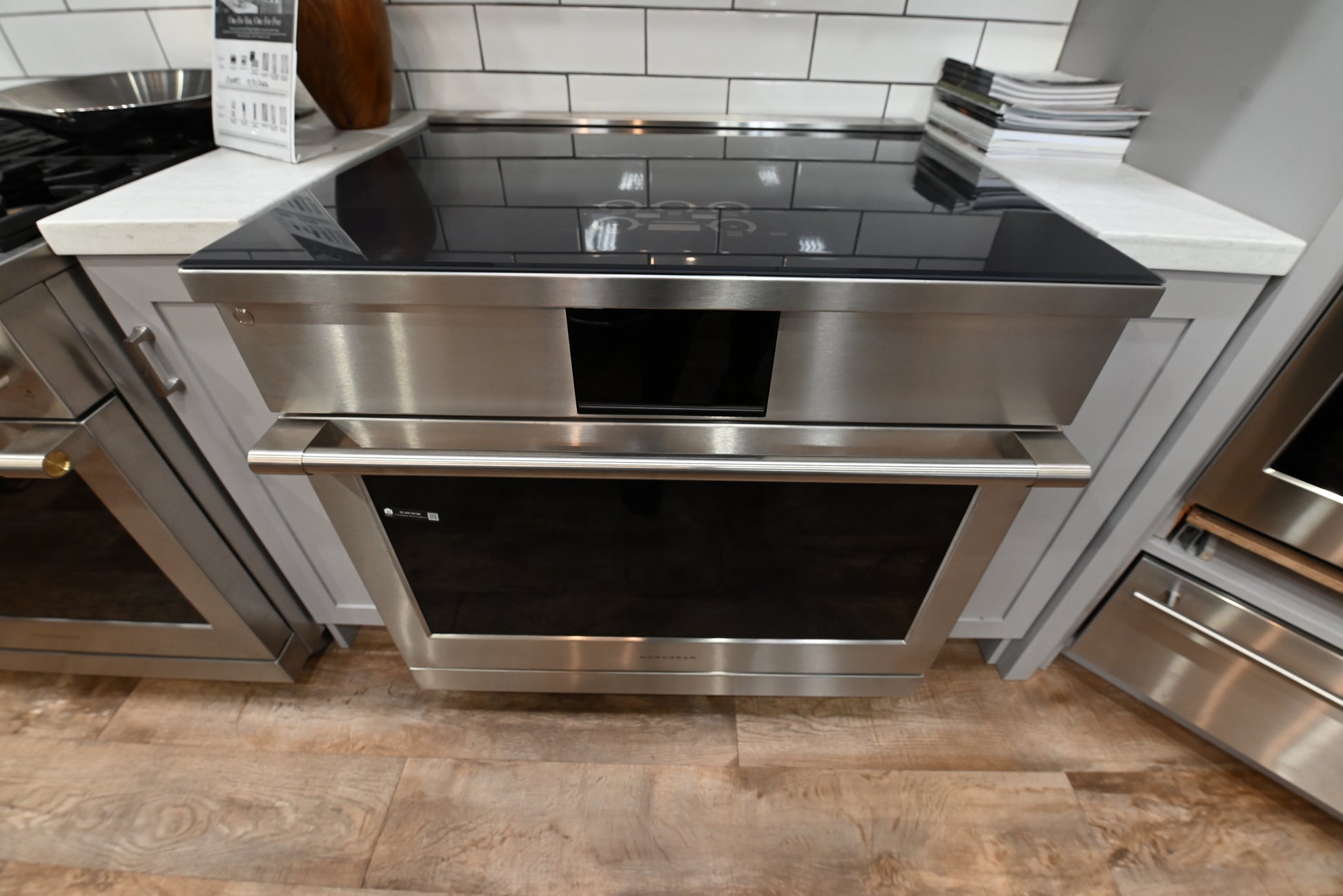 Monogram ZHP365ETVSS 36 inch professional induction range in stainless steel with a seamless black glass cooktop and brass-accented handle