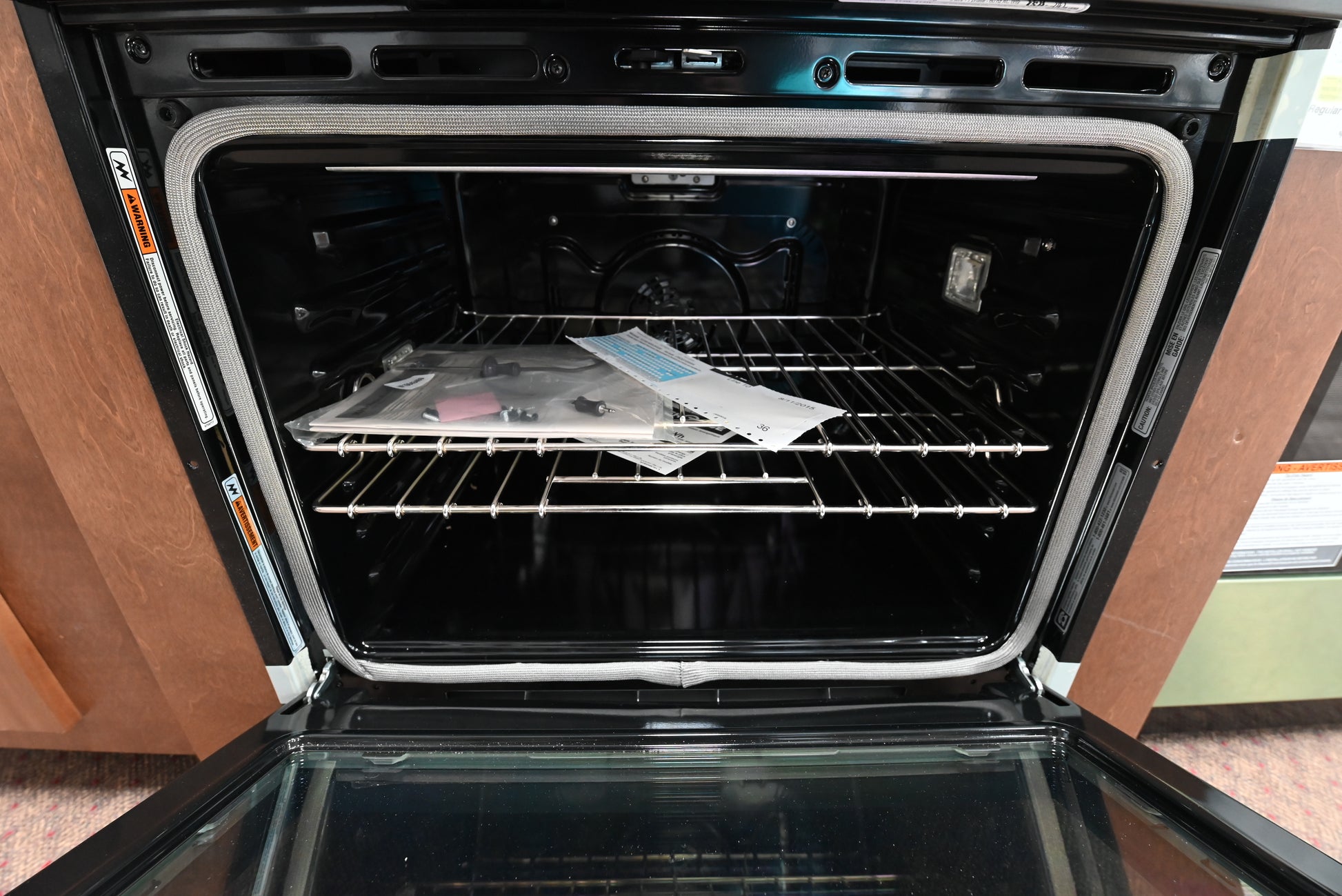 Luxury built in single oven door open showing blue porcelain interior cavity and satinglide roll out rack