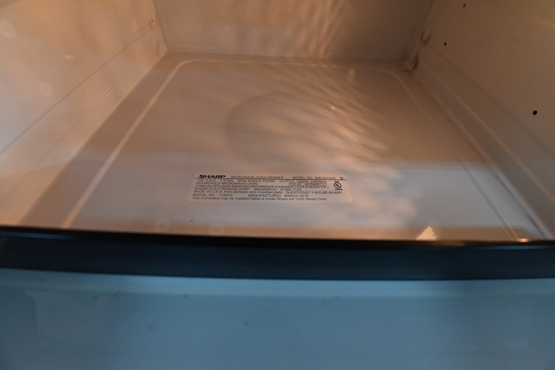 Close up view of the 45 degree tilt up control panel and open motorized drawer of the Sharp SMD3070AS microwave drawer