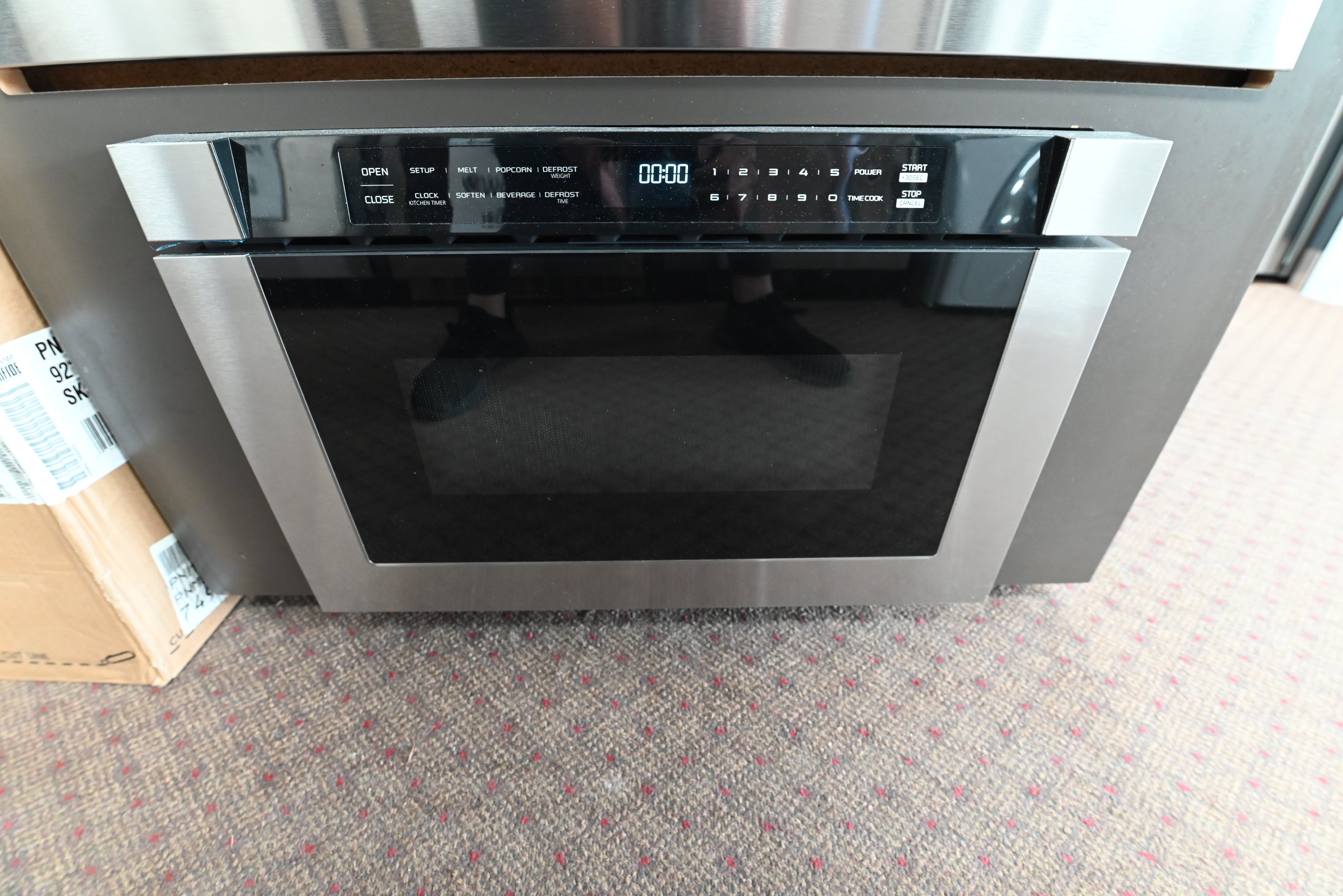 XO XOMWD24S 24 inch built in microwave drawer in stainless steel with a black glass front mounted under a counter