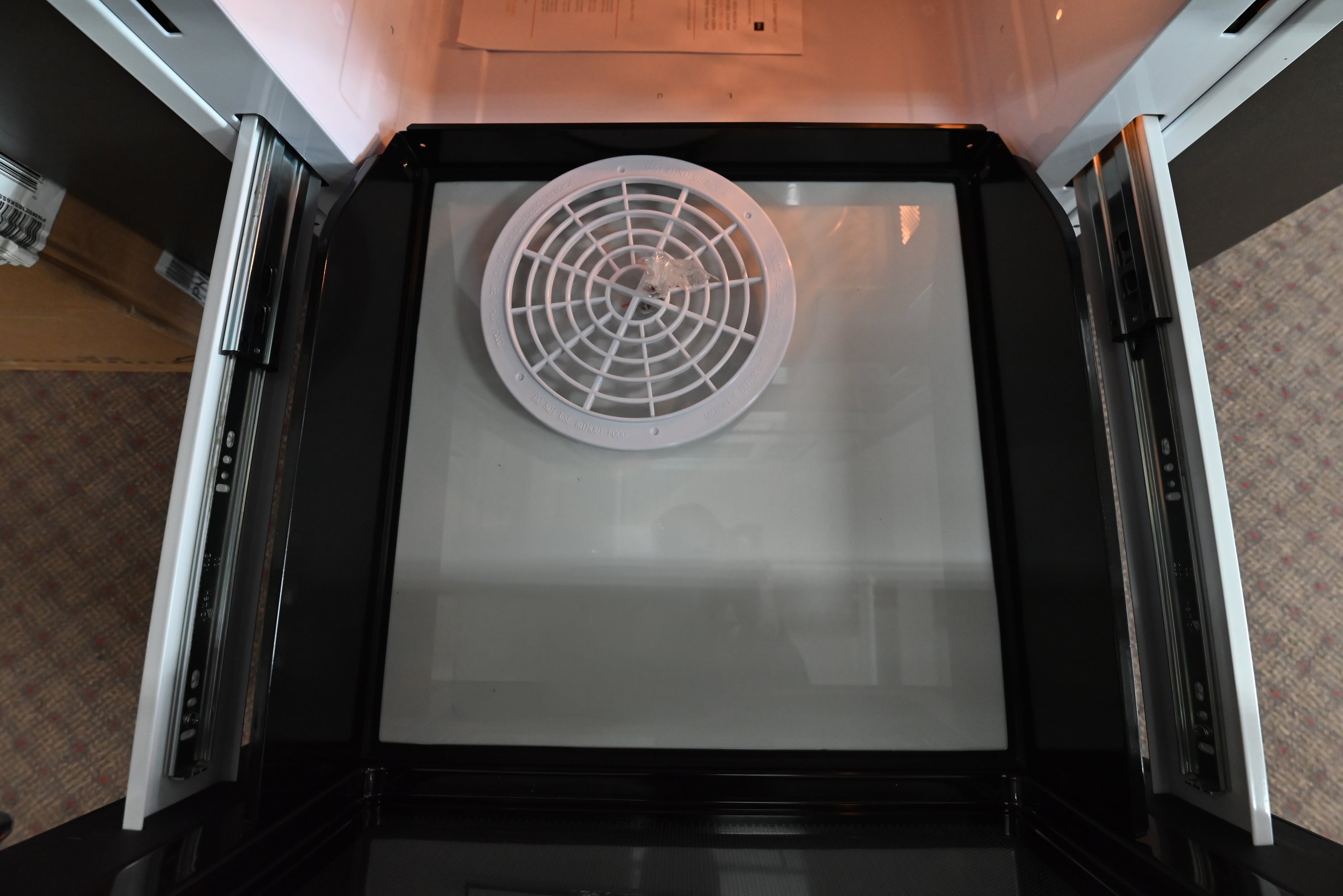 Close up view of the top touch control panel and open motorized drawer of the XO XOMWD24S microwave drawer