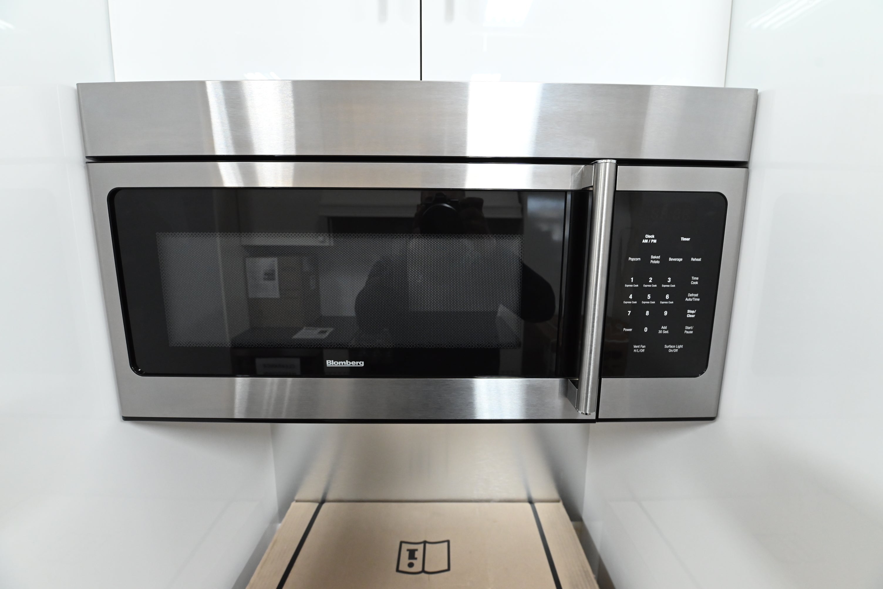 Luxury 30 inch over the range microwave open showing easy clean commercial stainless steel interior cavity and glass turntable