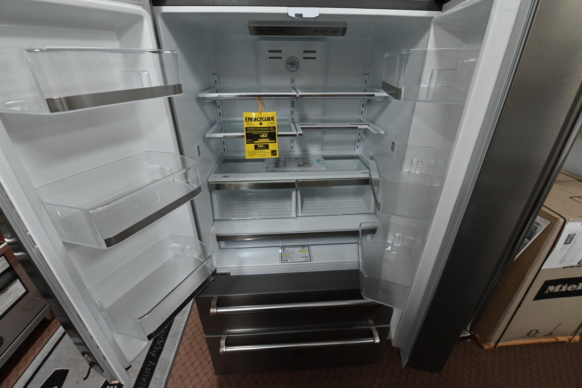 Luxury 36 inch counter depth refrigerator doors open showing white interior shelves crispers and LED lighting