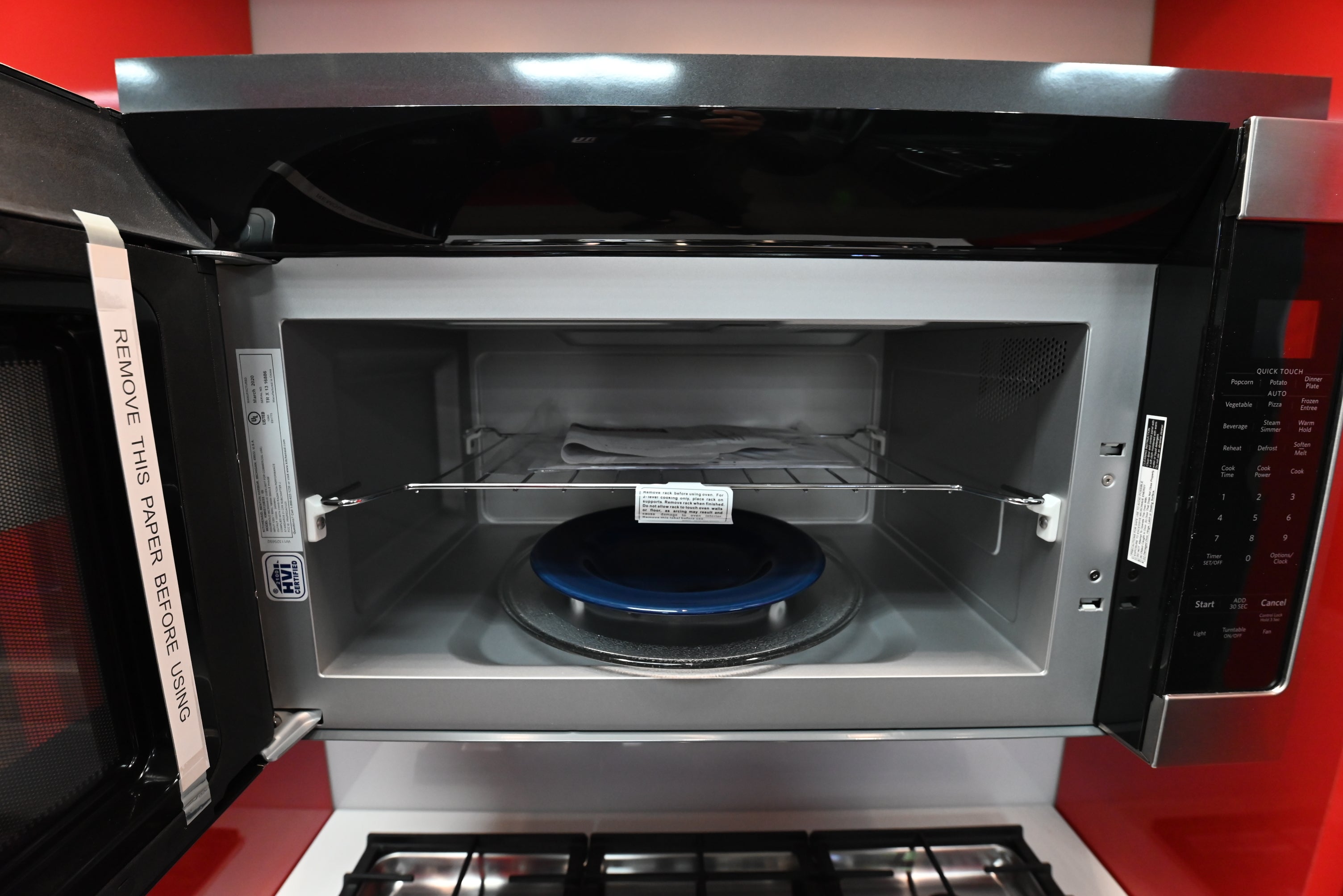 Open door view of a KitchenAid KMHS120ESS microwave showing the dark CookShield interior and glass turntable
