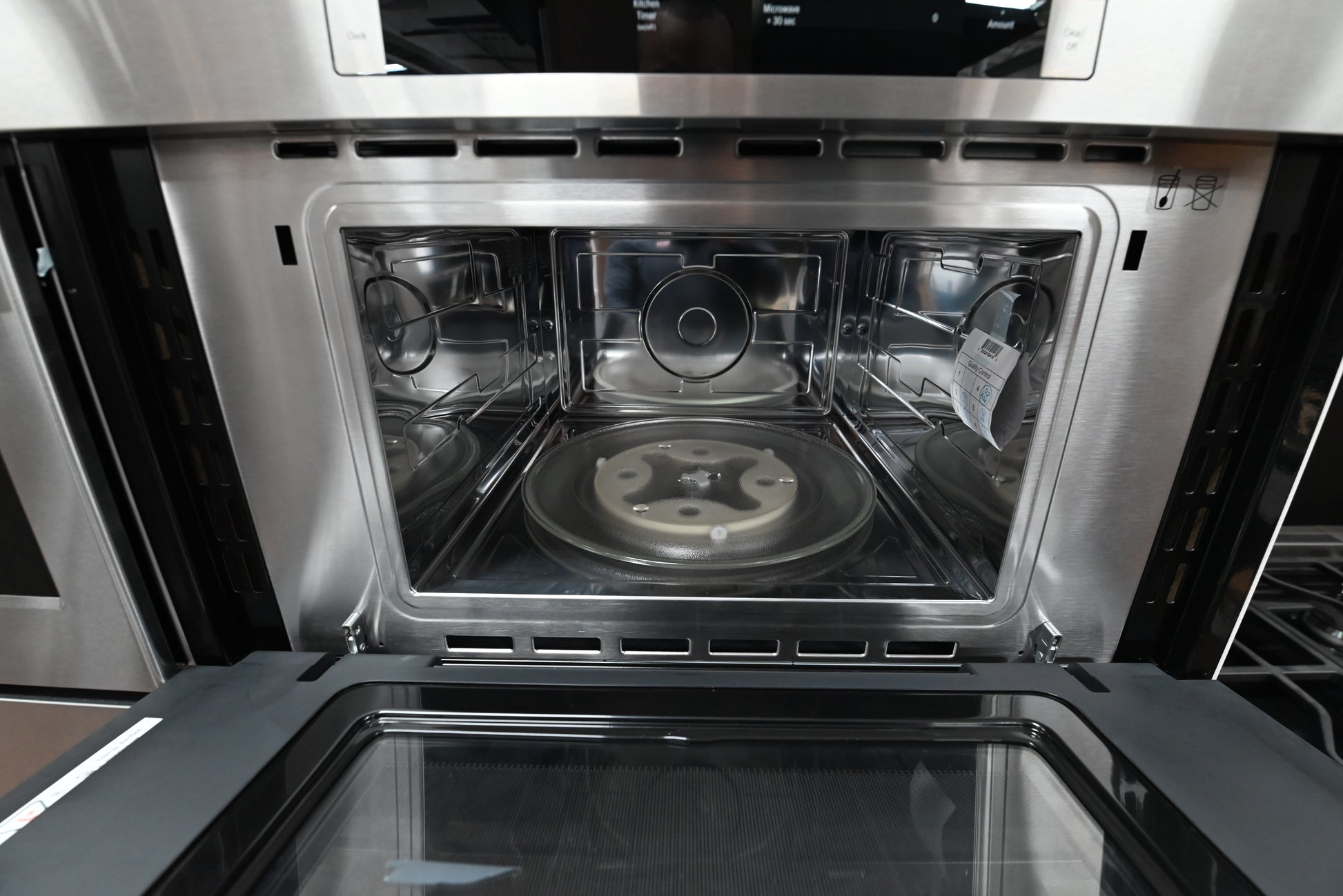 Luxury 30 inch integrated combo oven open showing upper microwave turntable and lower convection racks