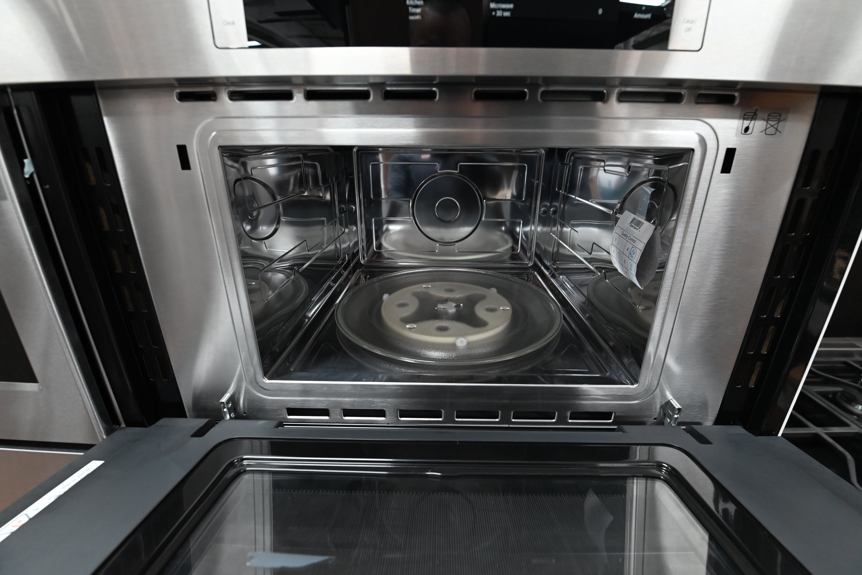 Luxury 30 inch integrated combo oven open showing upper microwave turntable and lower convection racks