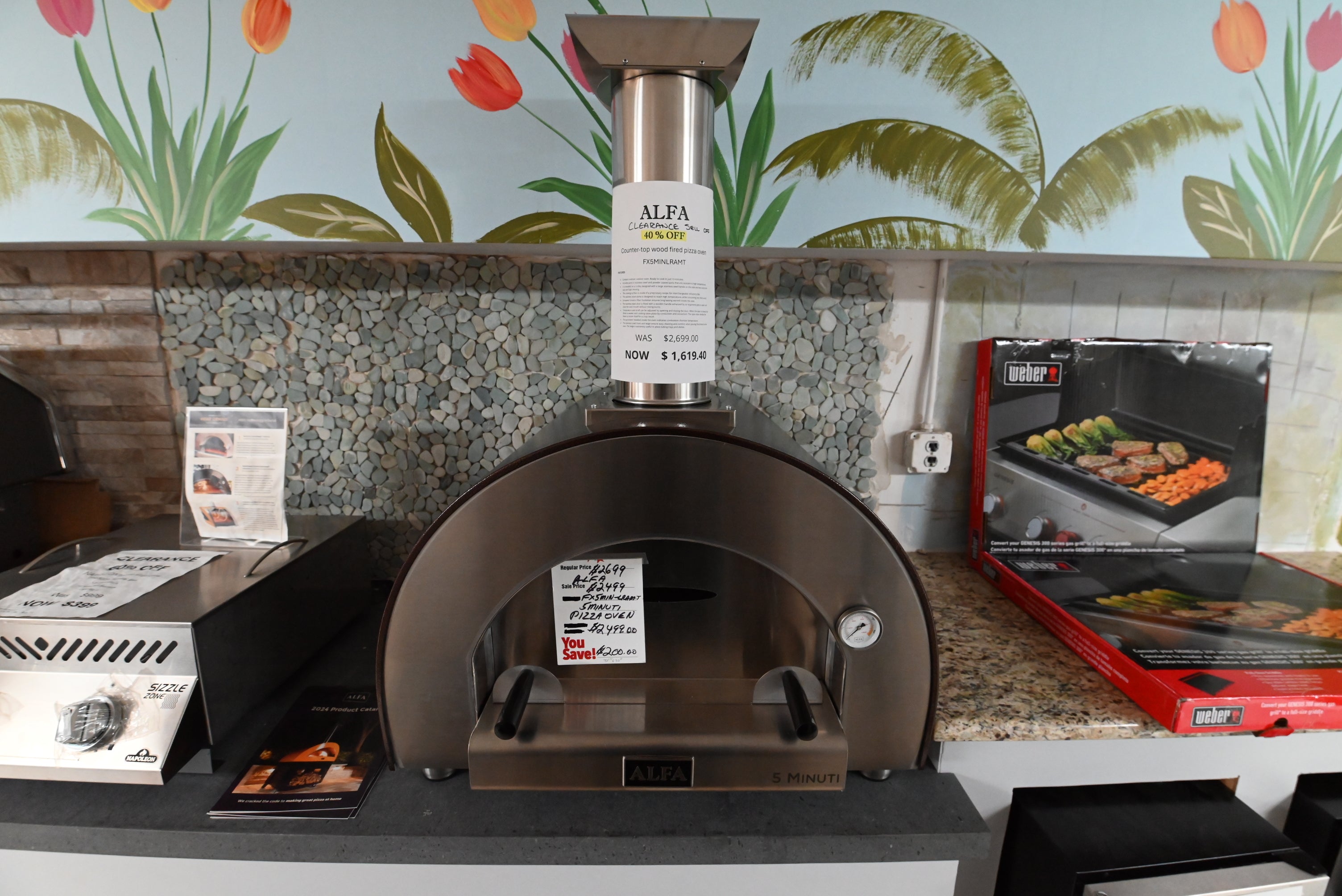 Luxury Italian outdoor countertop pizza oven open showing glowing wood fire and refractory brick floor